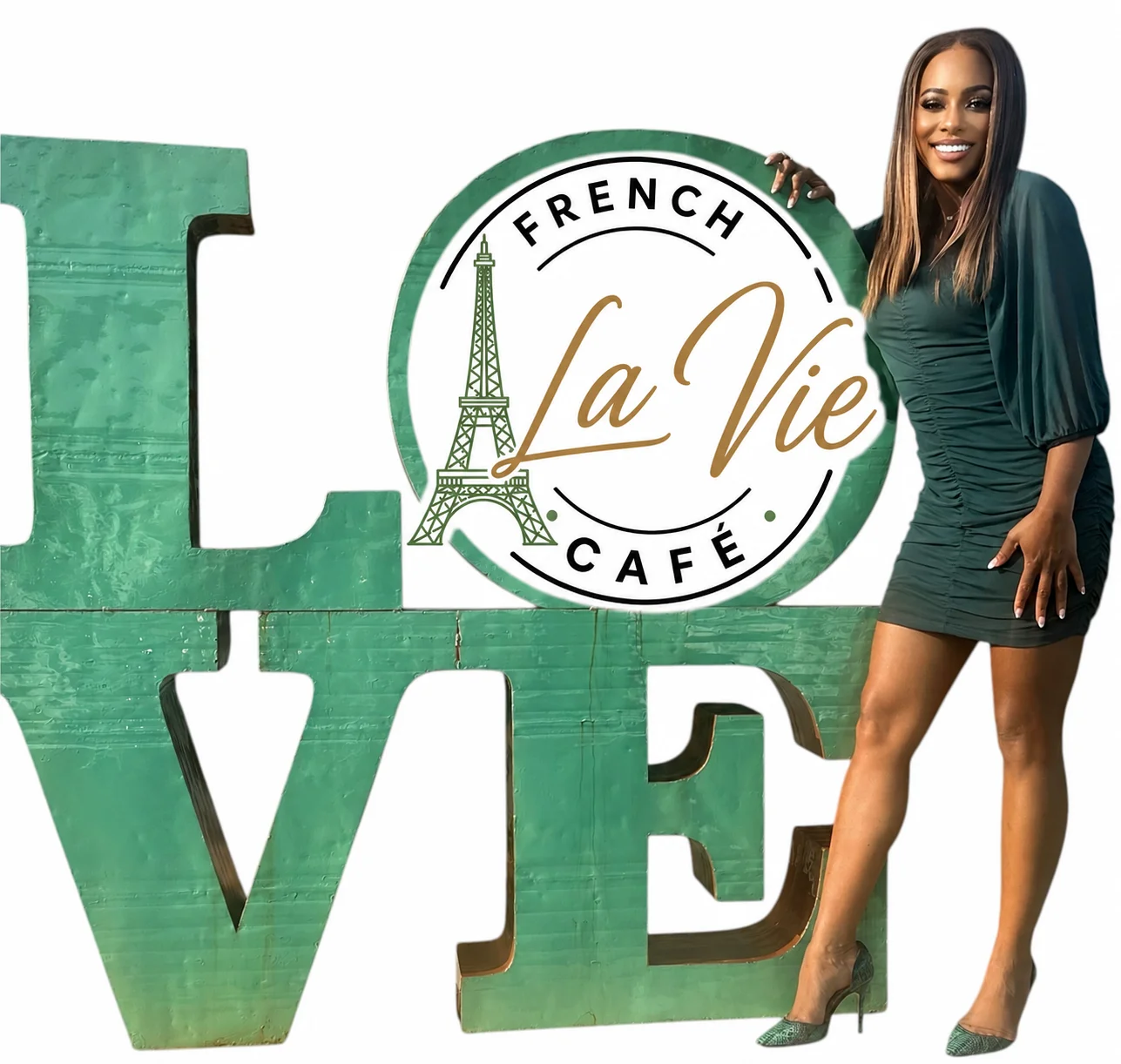 Woman in green dress posing next to 'LOVE' sign for La Vie French Café