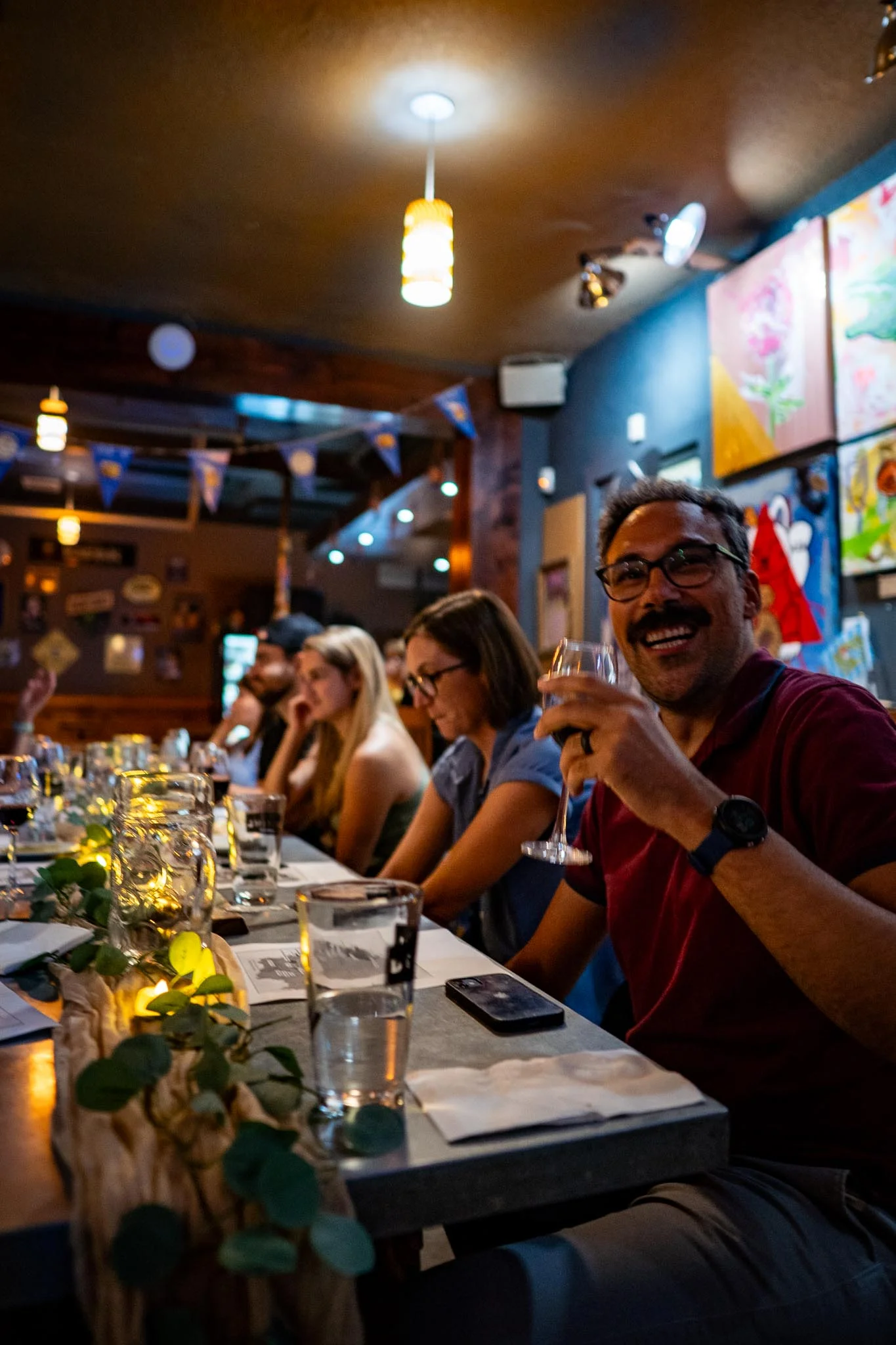 Lively restaurant gathering with guests enjoying drinks and conversation.