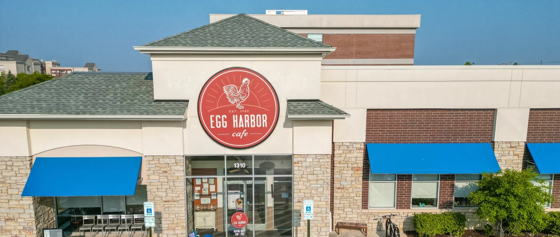 Exterior view of Egg Harbor Cafe with a welcoming sign