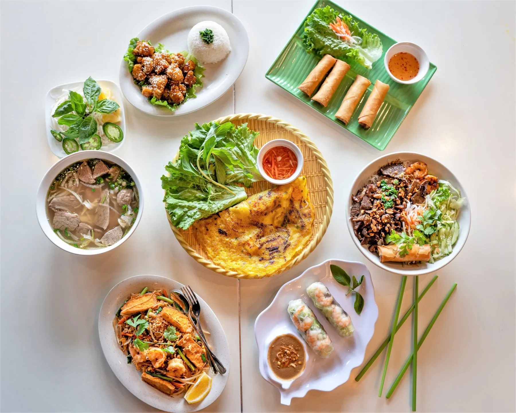 Assorted Vietnamese dishes including pho, spring rolls, and banh xeo