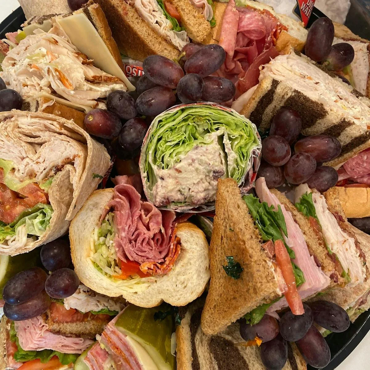 Assorted deli sandwich platter with fresh grapes