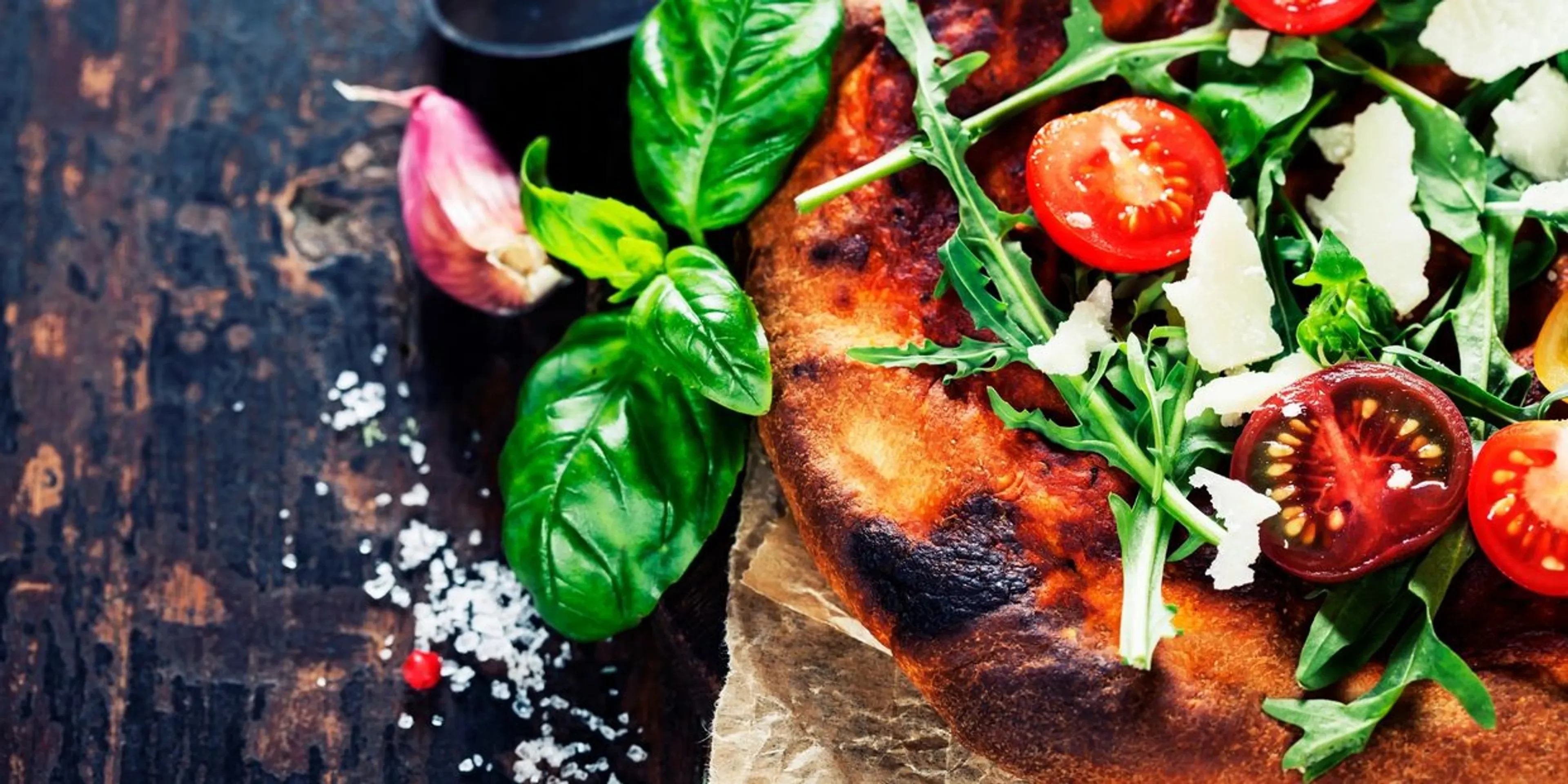 Fresh Margherita pizza topped with arugula and cherry tomatoes