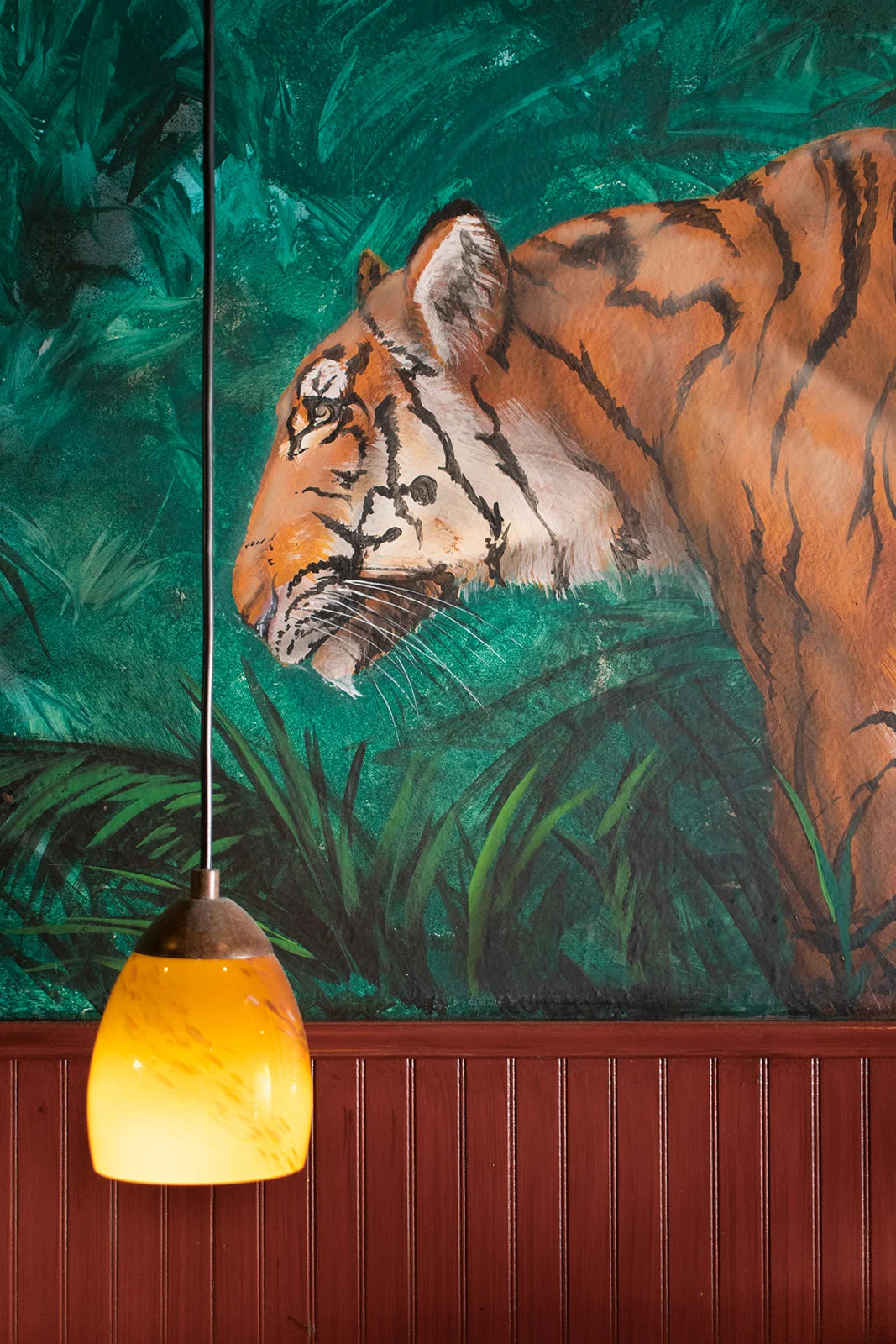 Artistic mural of a tiger in a vibrant restaurant setting