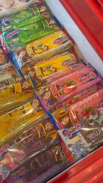 A colorful assortment of frozen treats packed in wrappers. Various flavors are available, displayed neatly in a freezer.