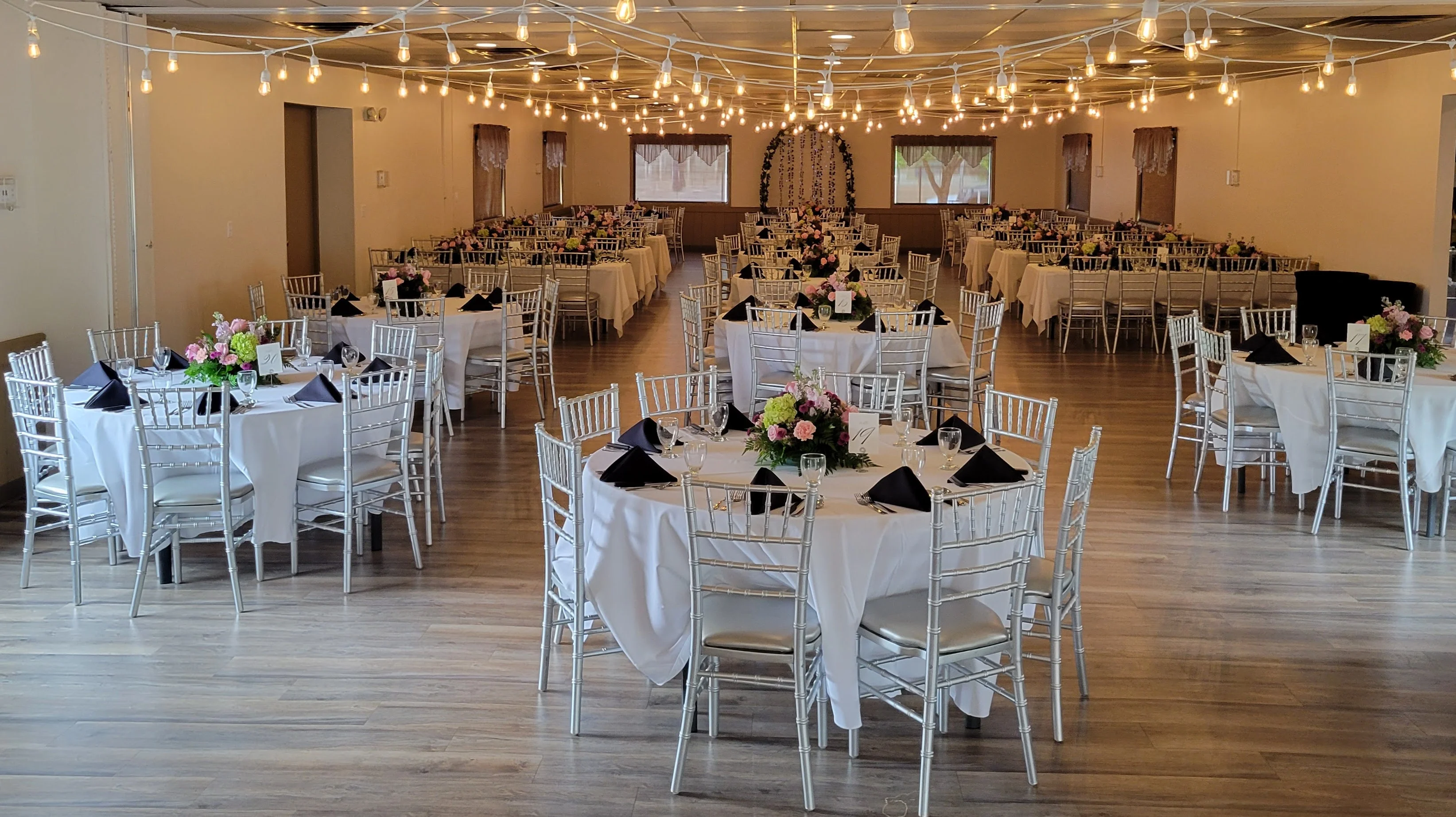 Elegant dining setup with floral centerpieces and string lights