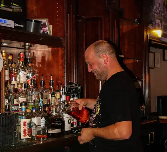 Bartender pouring whiskey at a stylish bar