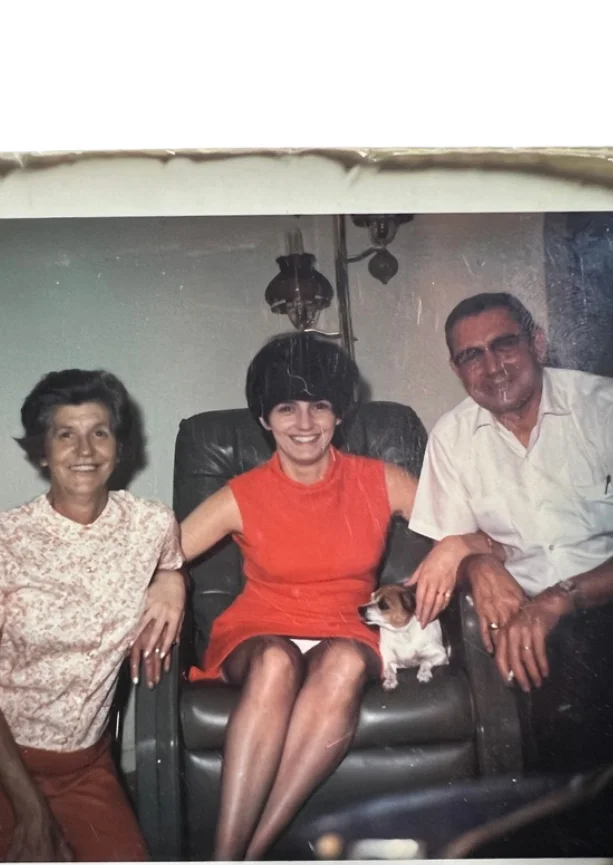 Family portrait with a woman in red dress and a small dog