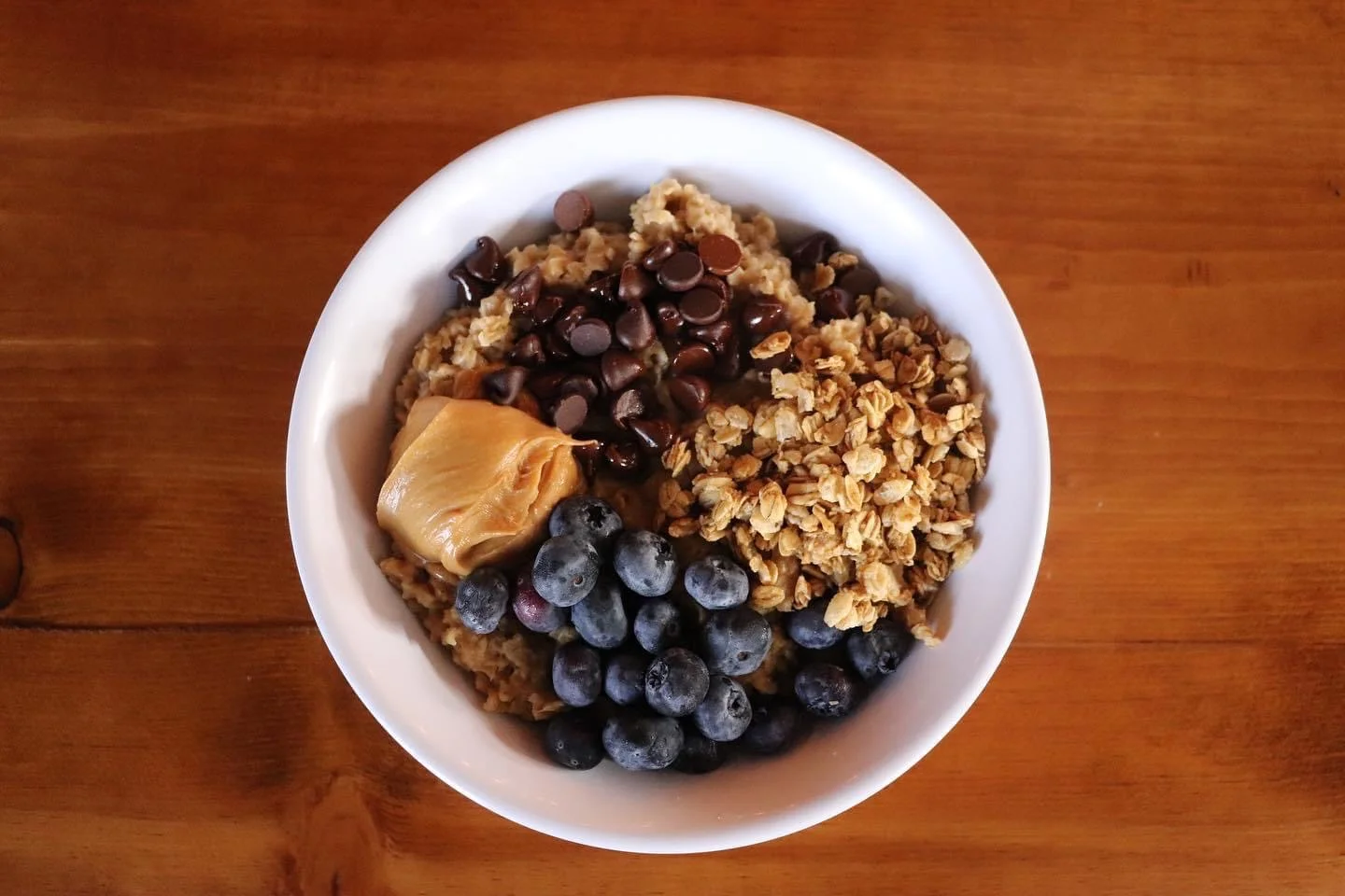 Bowl of oatmeal topped with blueberries and granola