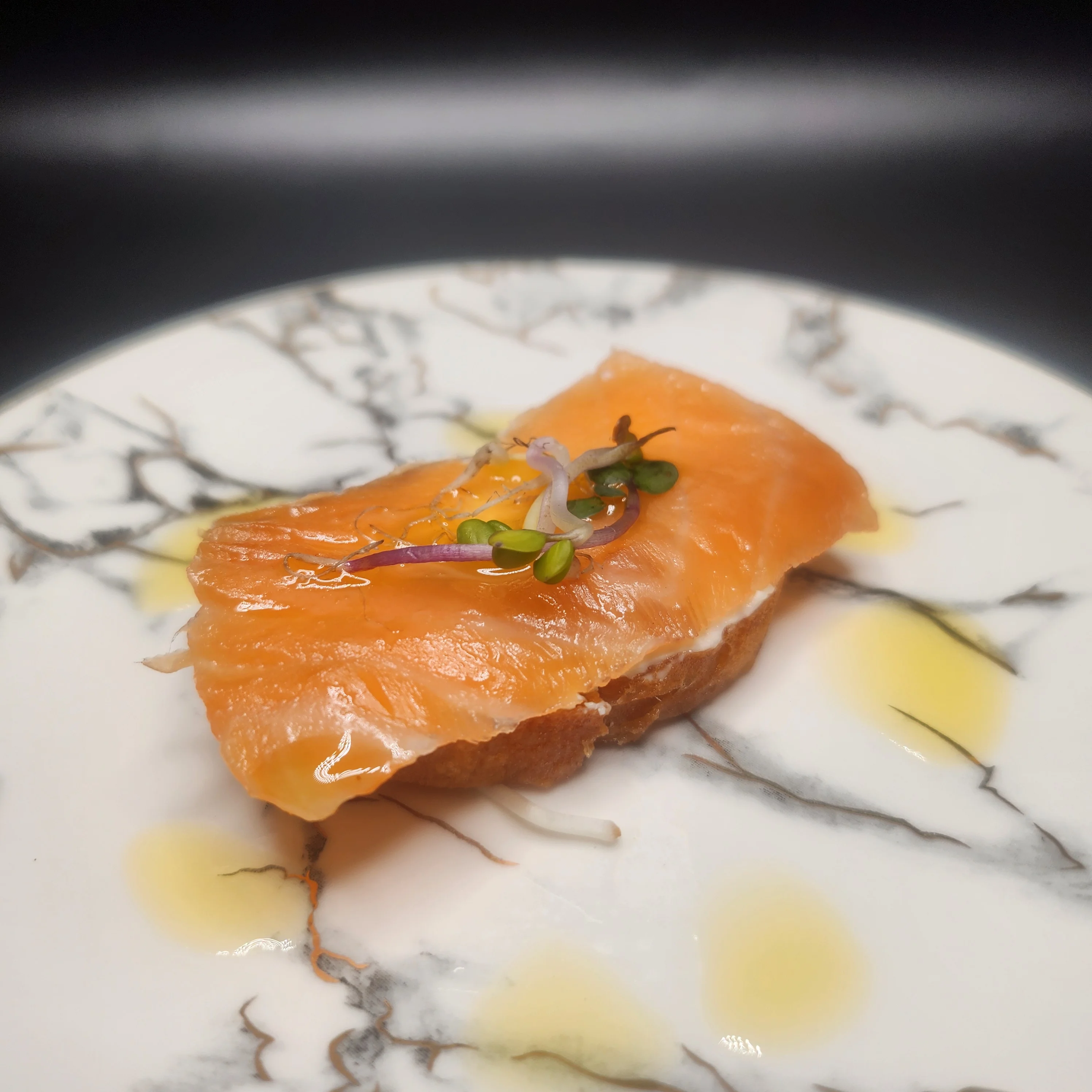Plate of smoked salmon with garnishes and a decorative presentation.