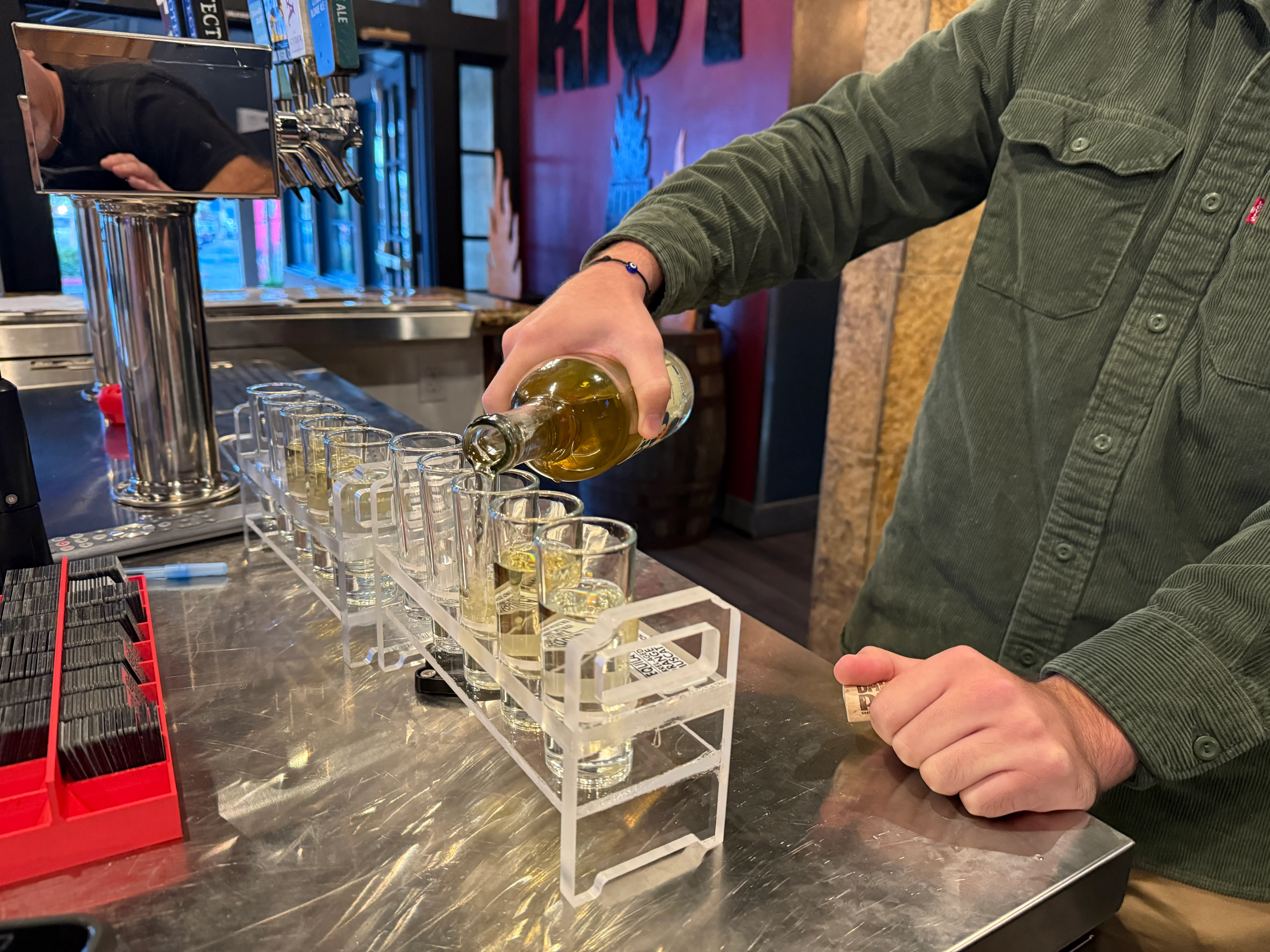 Bartender pouring shots at a lively bar counter