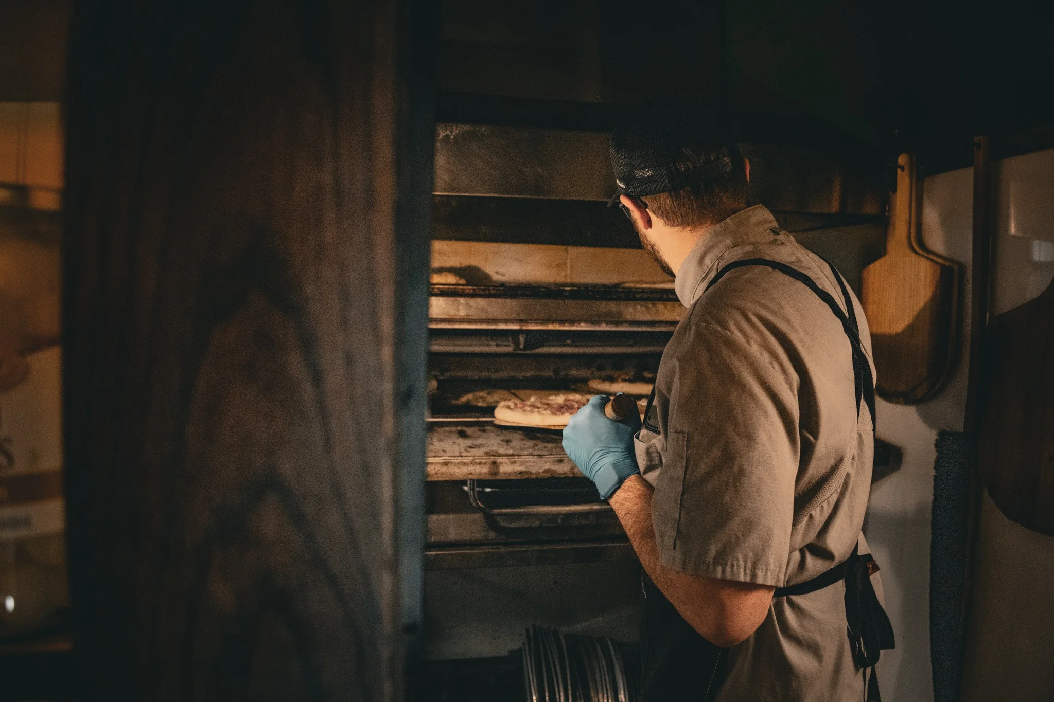 Chef placing pizza in a wood-fired oven