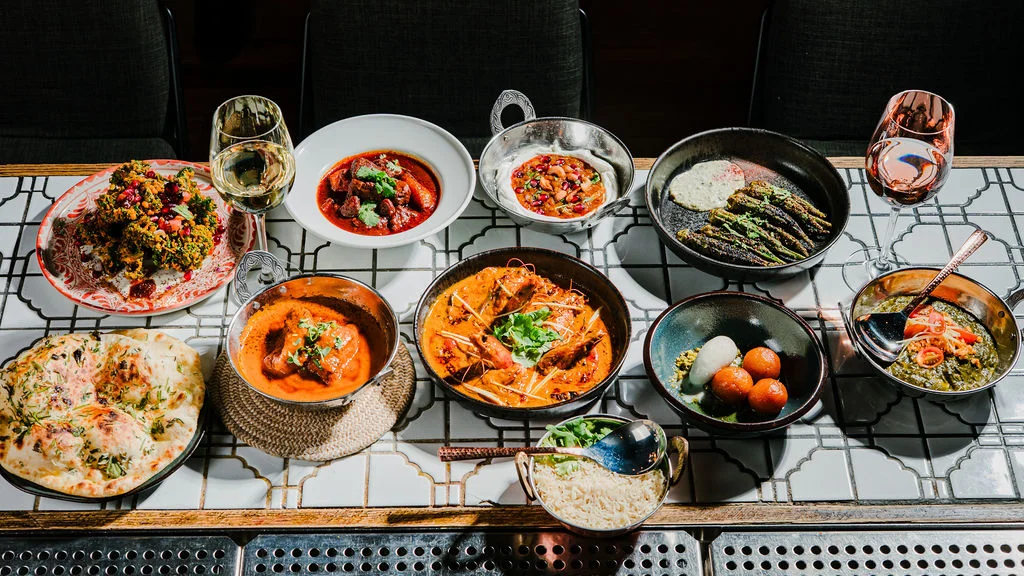 Assorted Indian dishes including curry and naan on a decorative table