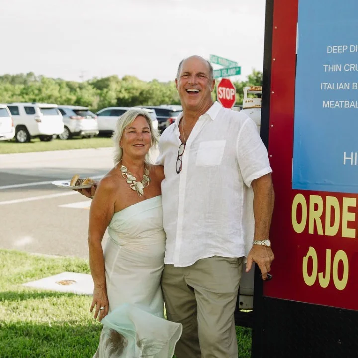 Couple enjoying a meal near a food truck serving Chicago-style pizza