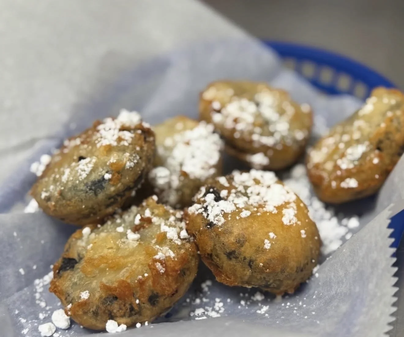 Fried beignets dusted with powdered sugar