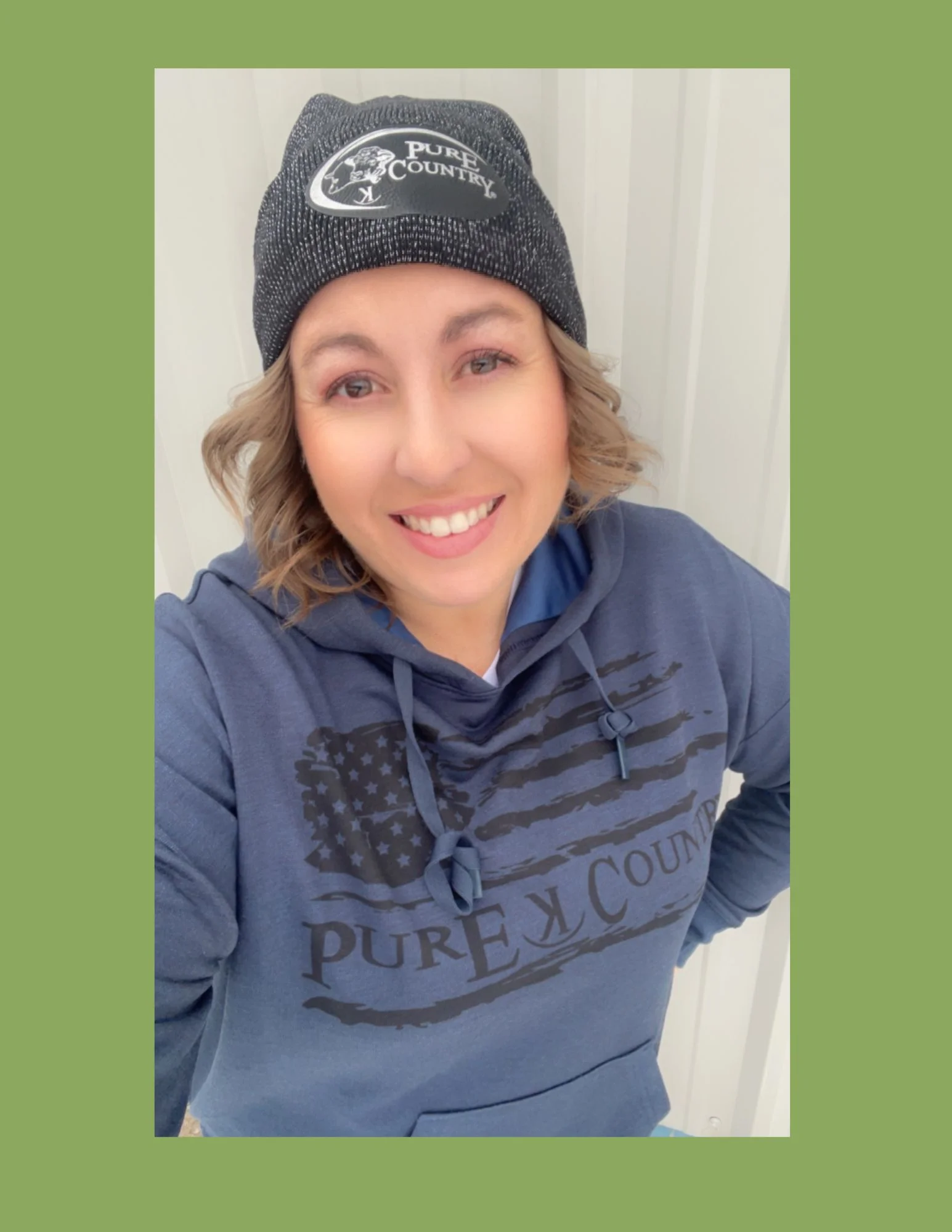 Smiling woman in casual attire with a beanie and hoodie