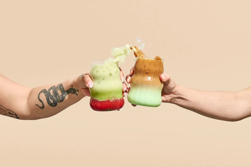 Colorful drinks clinking together in celebration