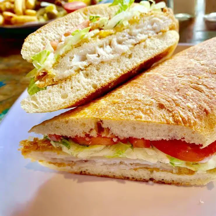 Crispy fish sandwich with lettuce and tomato