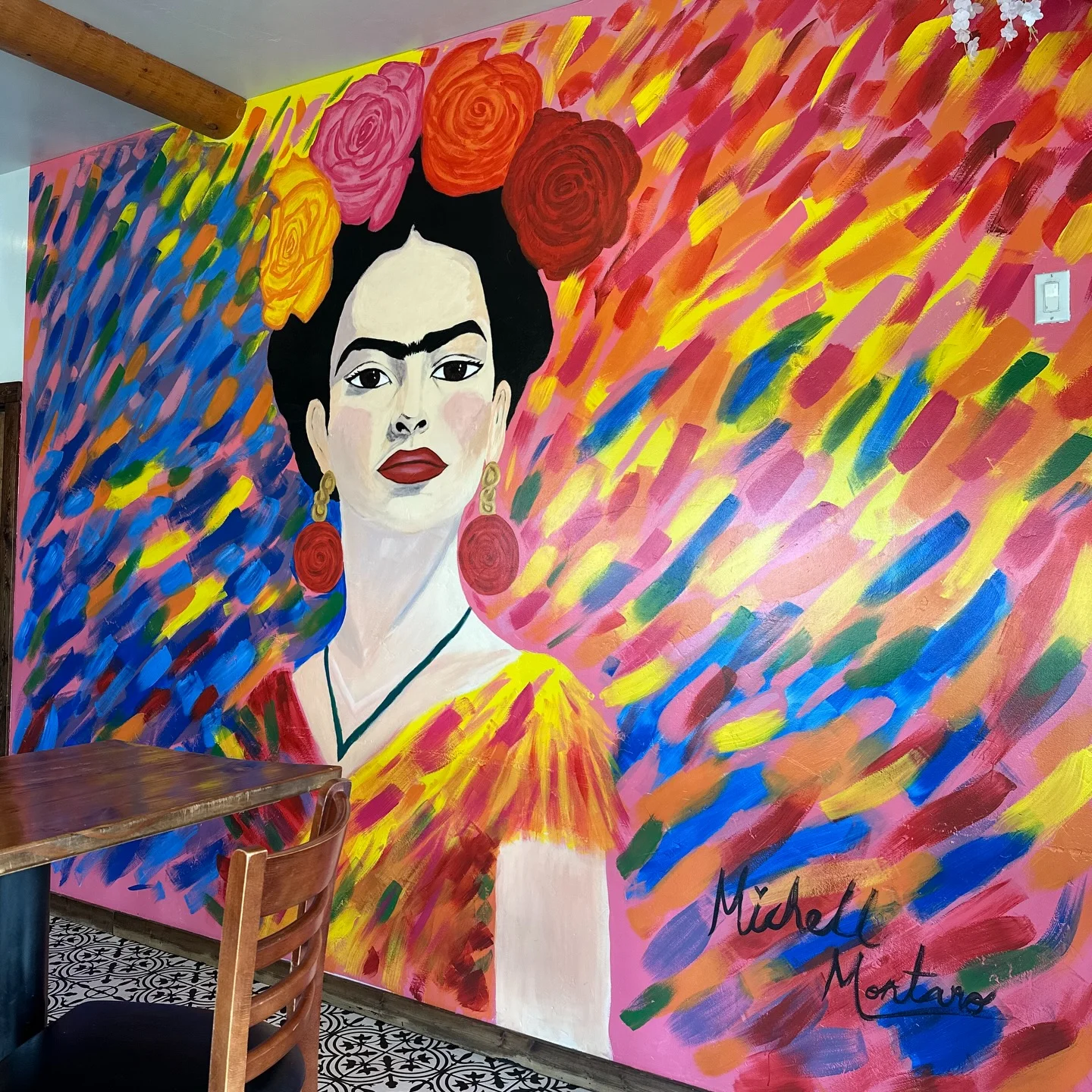 Vibrant mural of a woman with flowers in a colorful restaurant interior