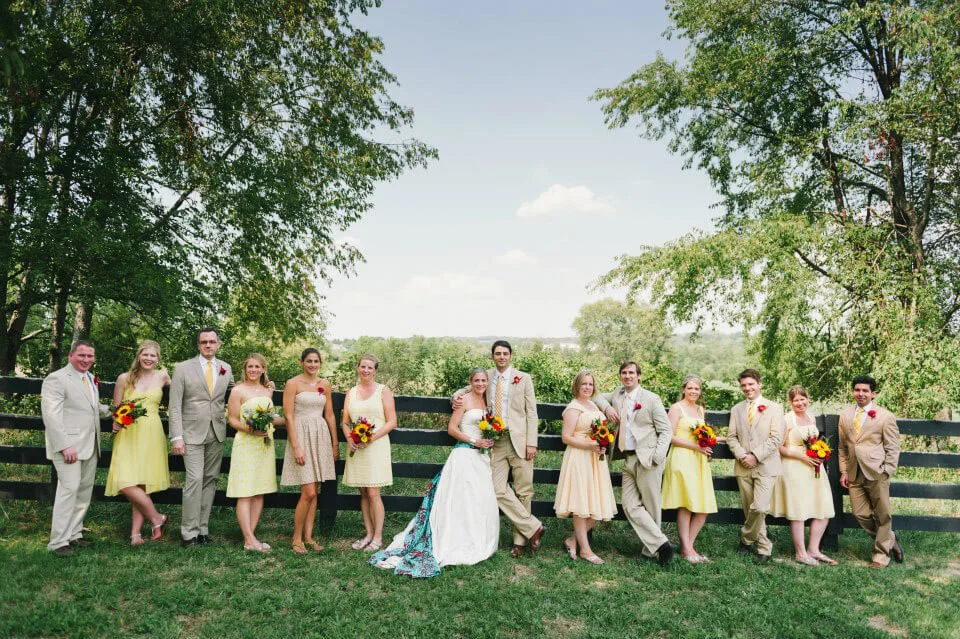 Wedding party in elegant attire outdoors with vibrant flowers