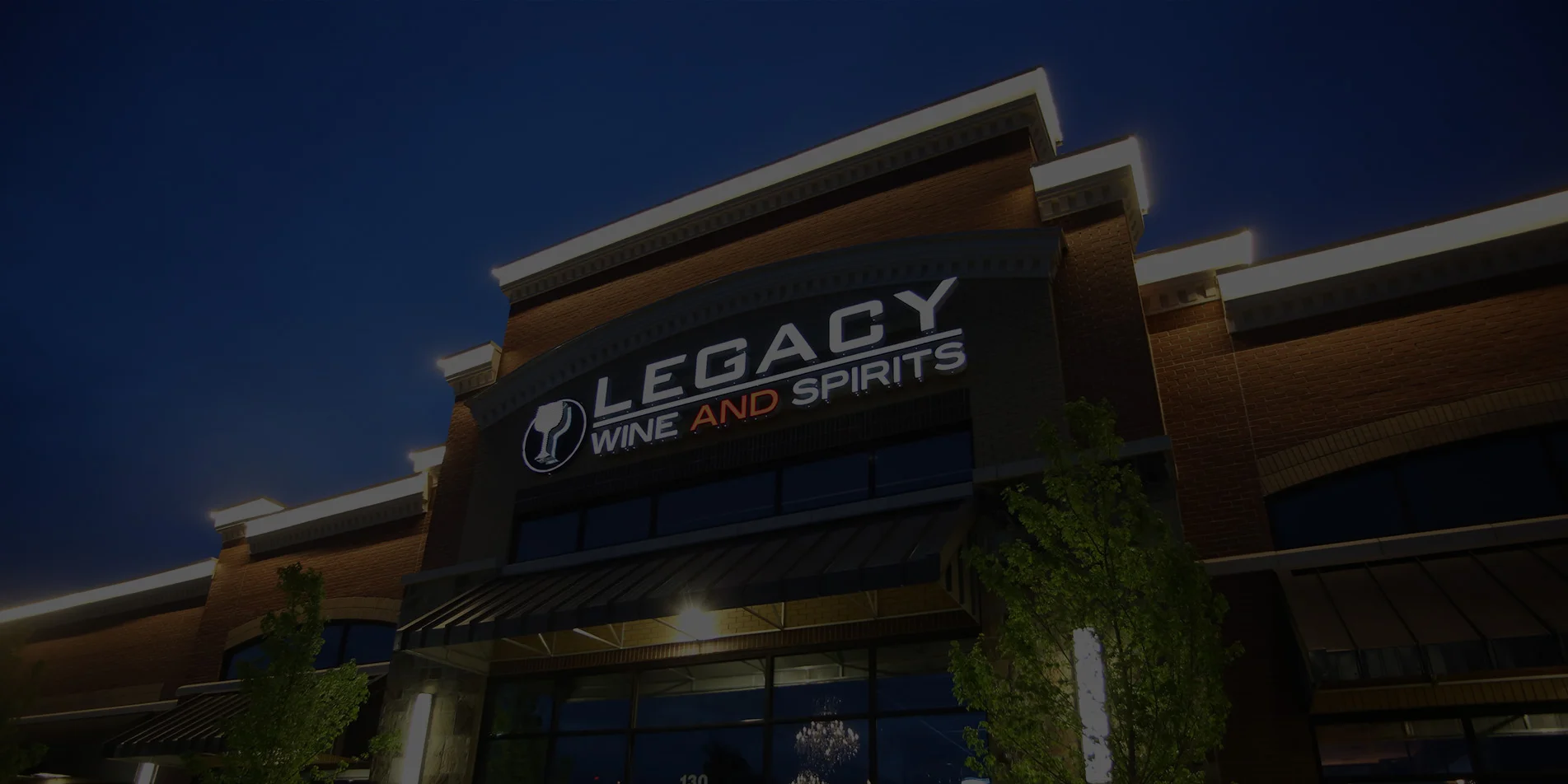 Exterior view of Legacy Wine and Spirits store at night