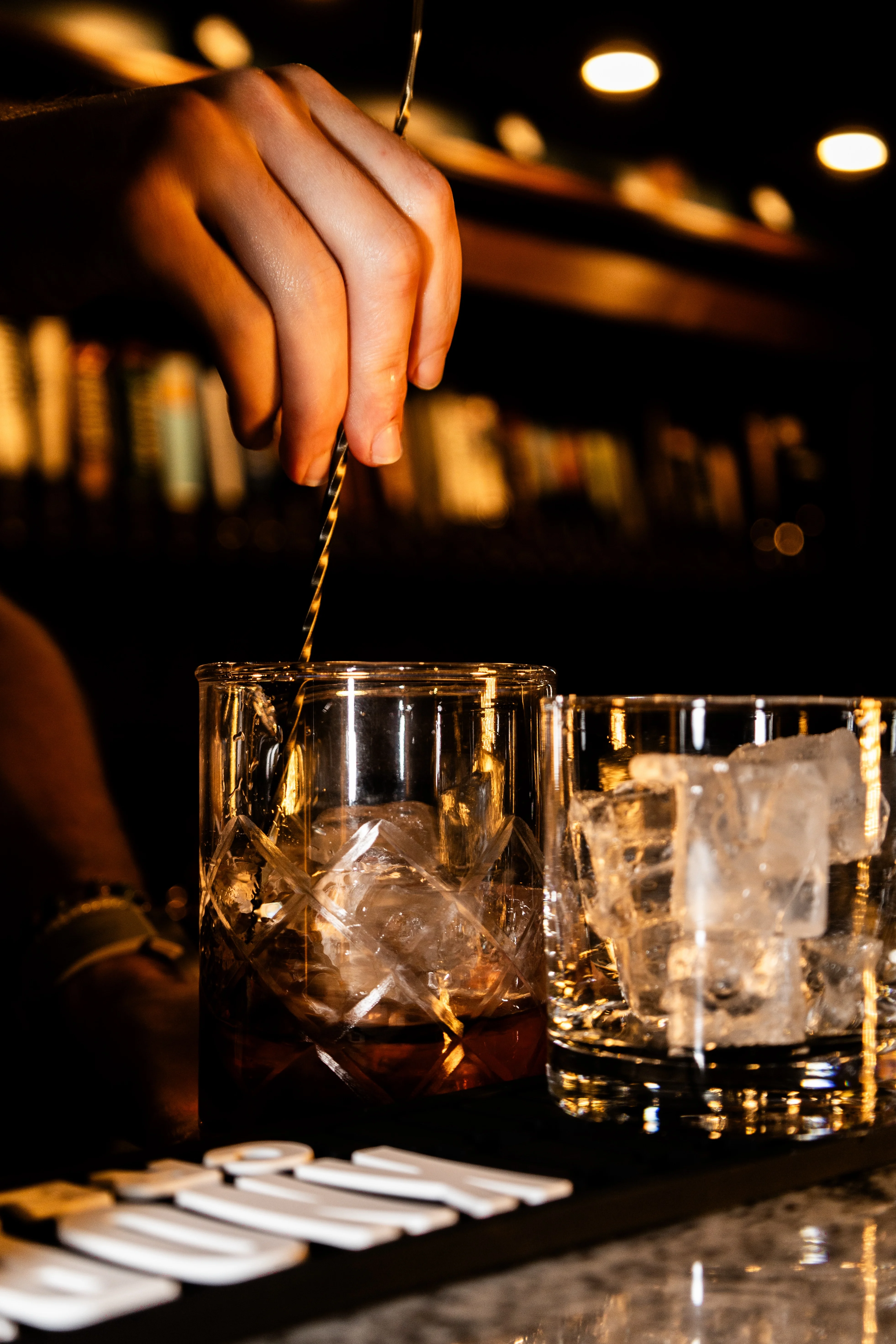 Bartender stirring a cocktail at a stylish bar