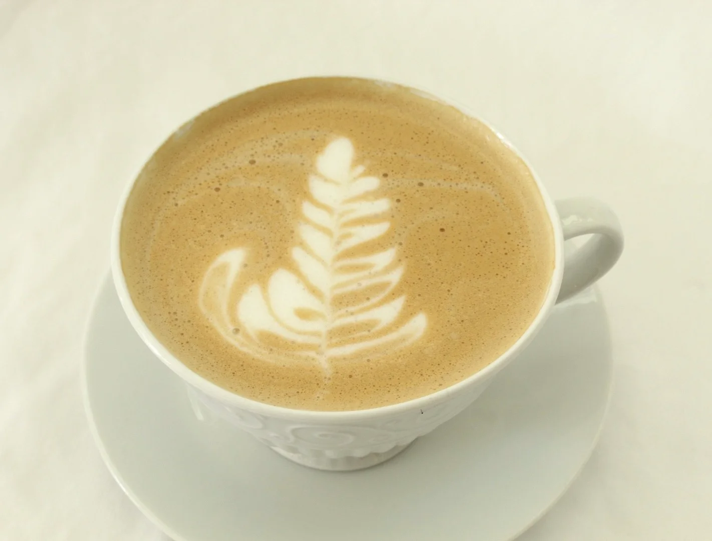 Cappuccino with latte art in a white cup