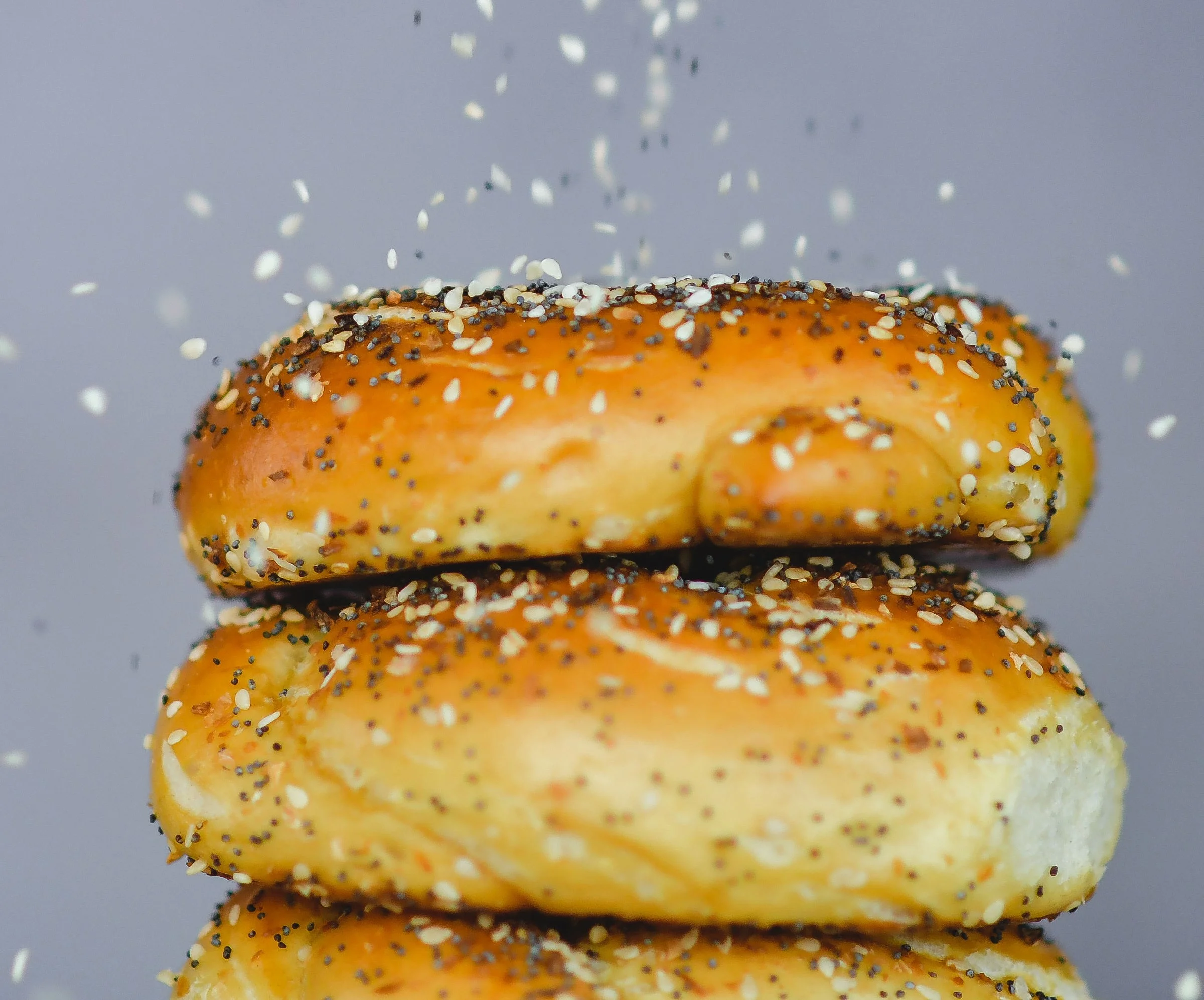 Freshly baked bagels topped with sesame and poppy seeds