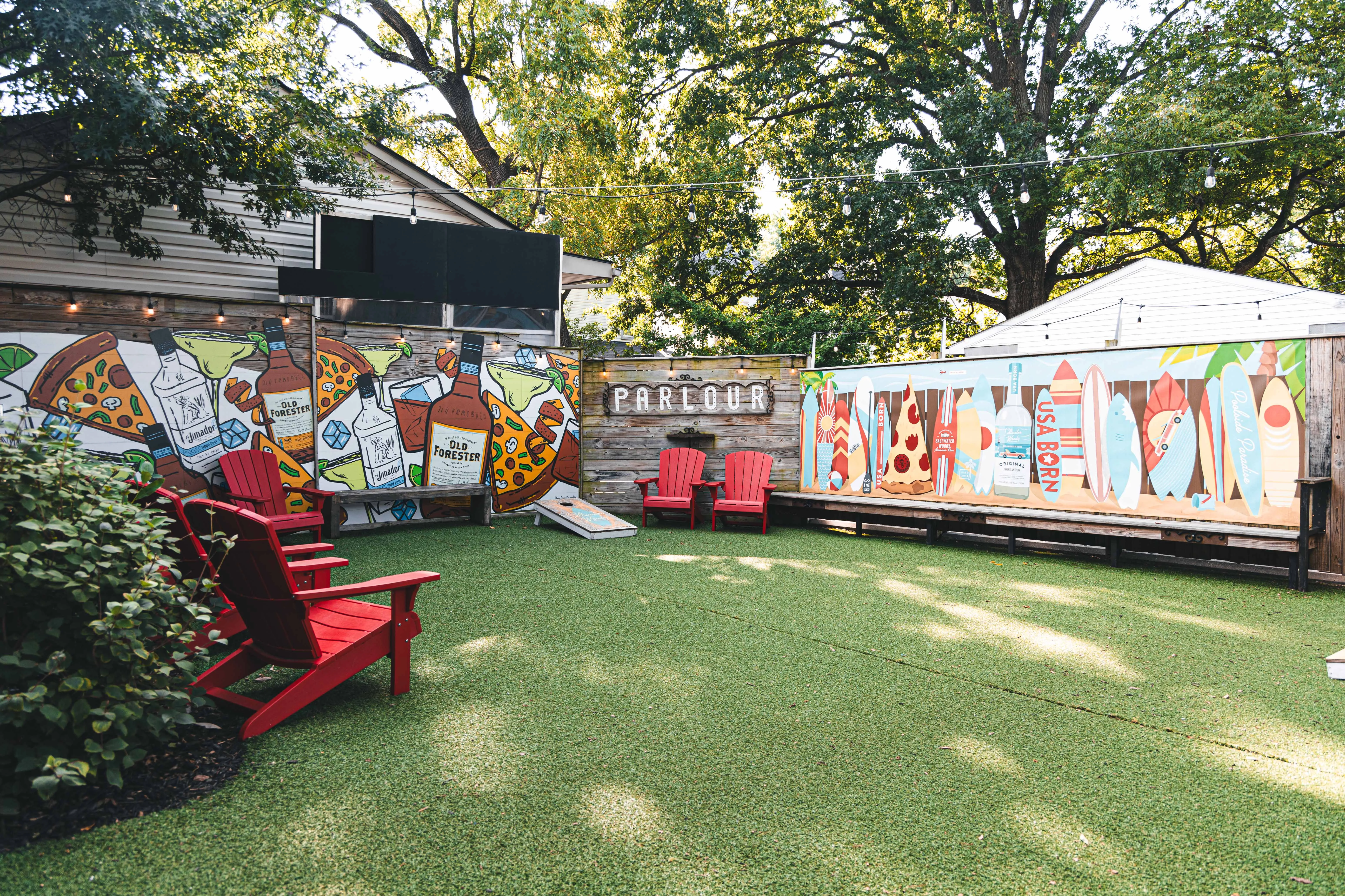 Outdoor dining area with vibrant murals and red chairs