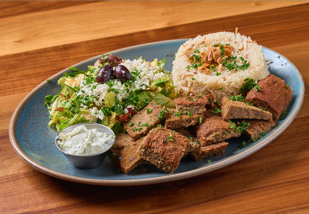 Gyro Platter with thin slices of roasted lamb, and tzatziki sauce.
