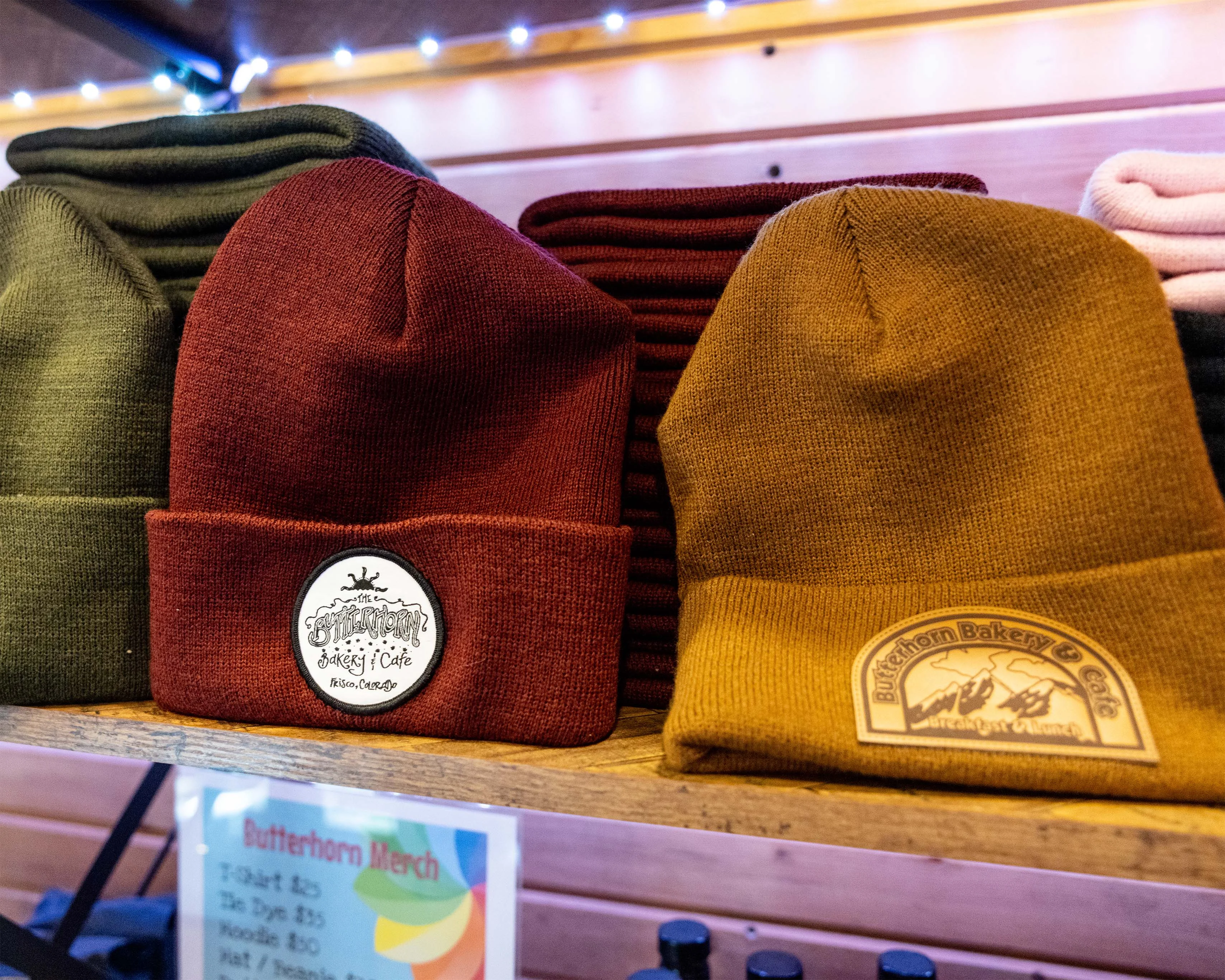 Colorful knit beanies displayed on a bakery cafe shelf