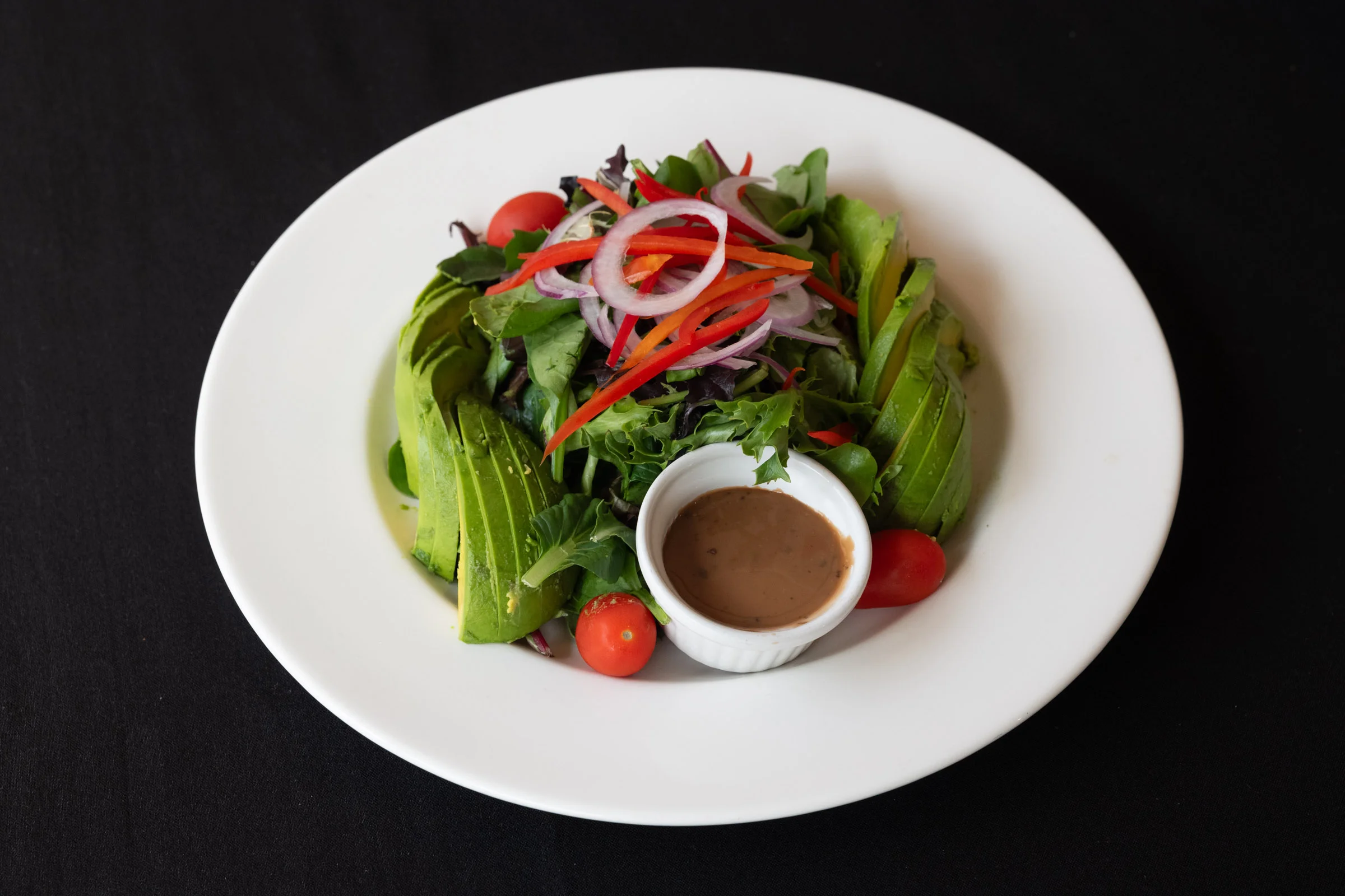 Fresh garden salad with avocado and vinaigrette dressing
