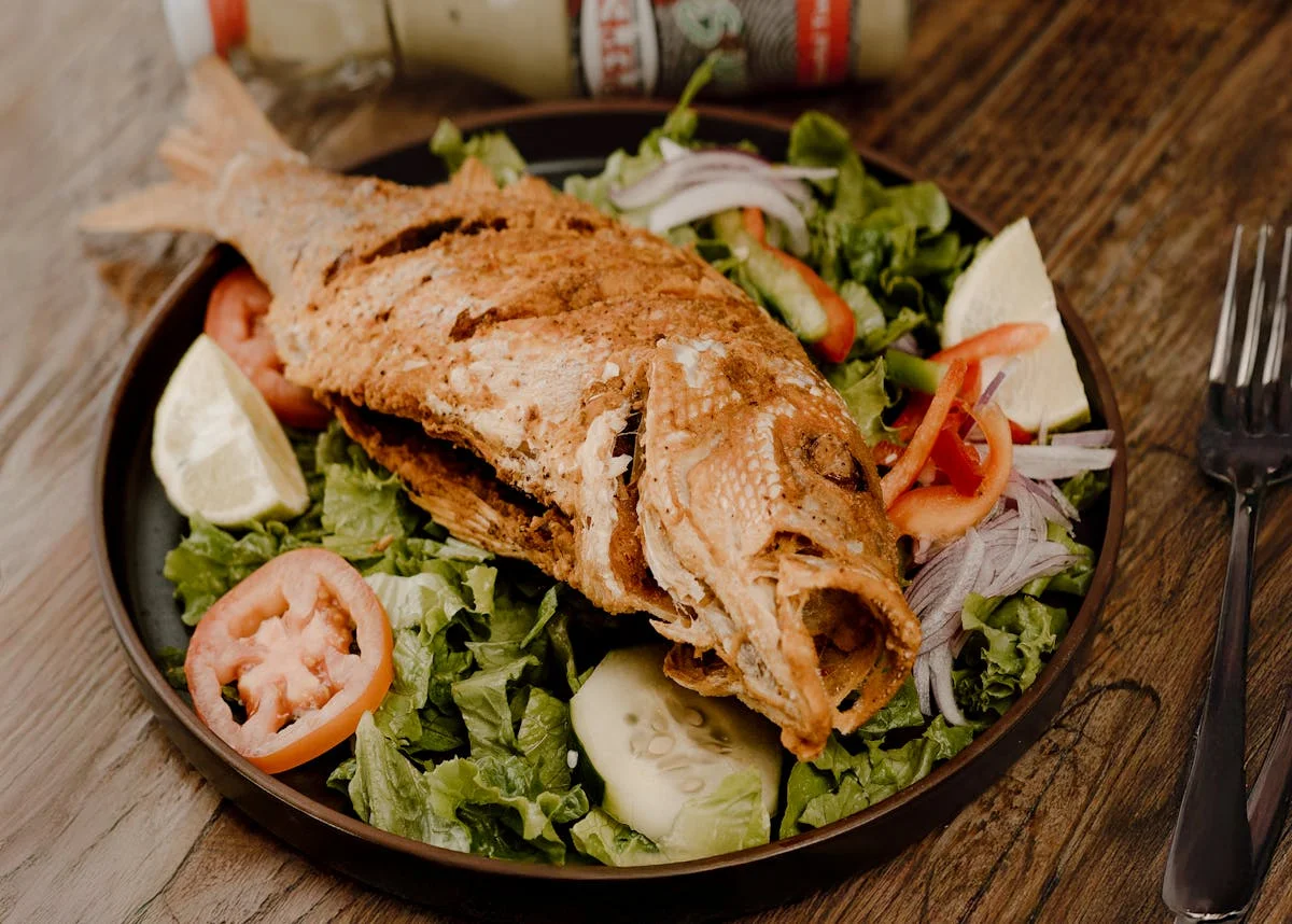 Fried whole fish served on a bed of fresh greens