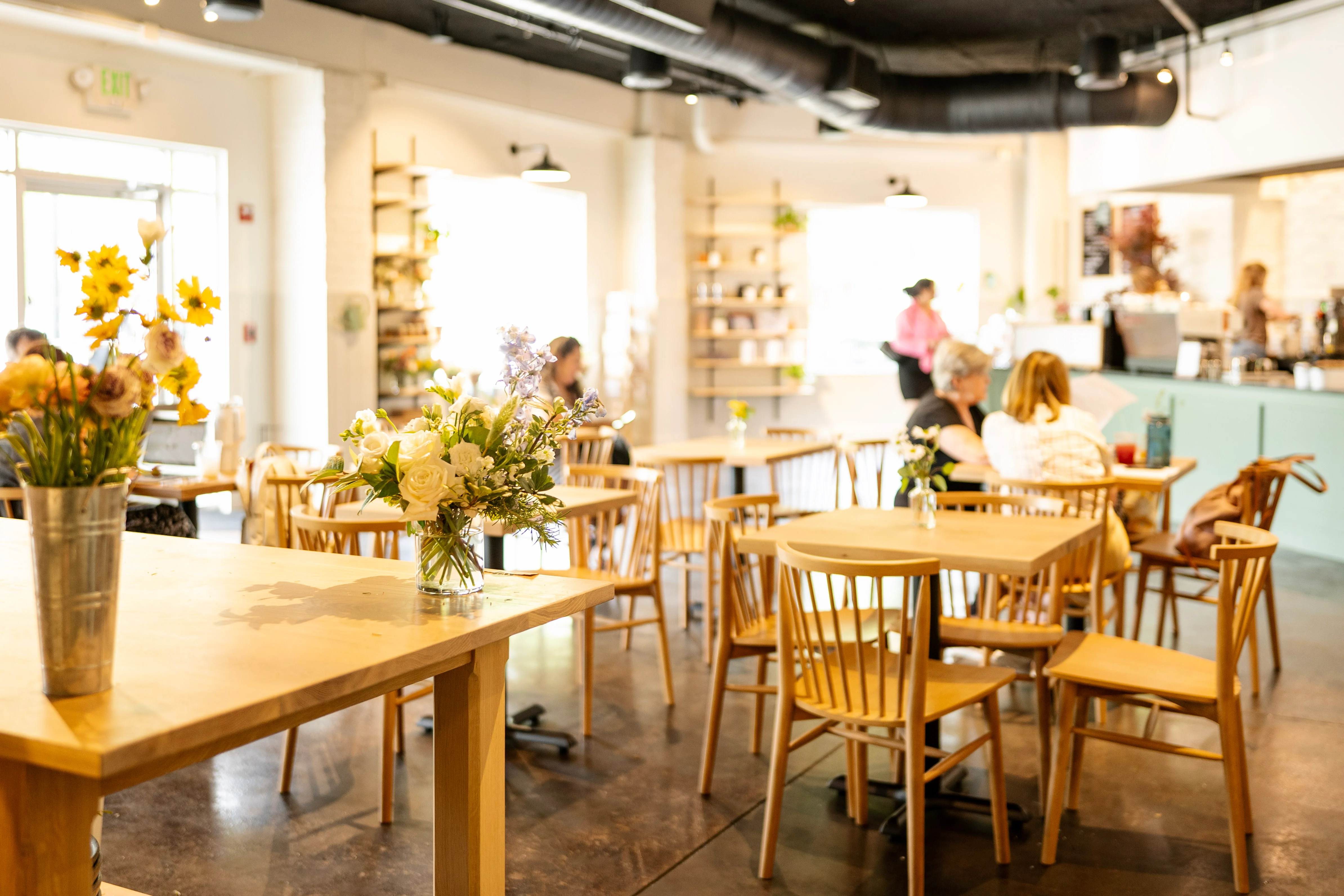 Cozy restaurant interior with wooden tables and floral arrangements