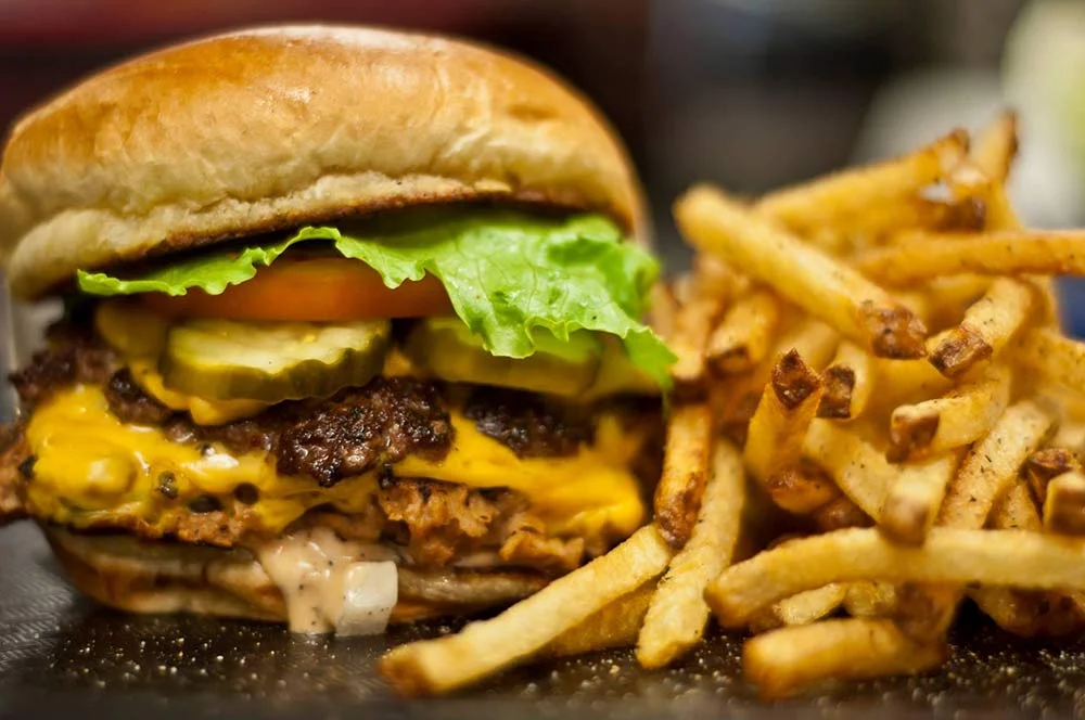 Juicy cheeseburger with fries served in a casual diner