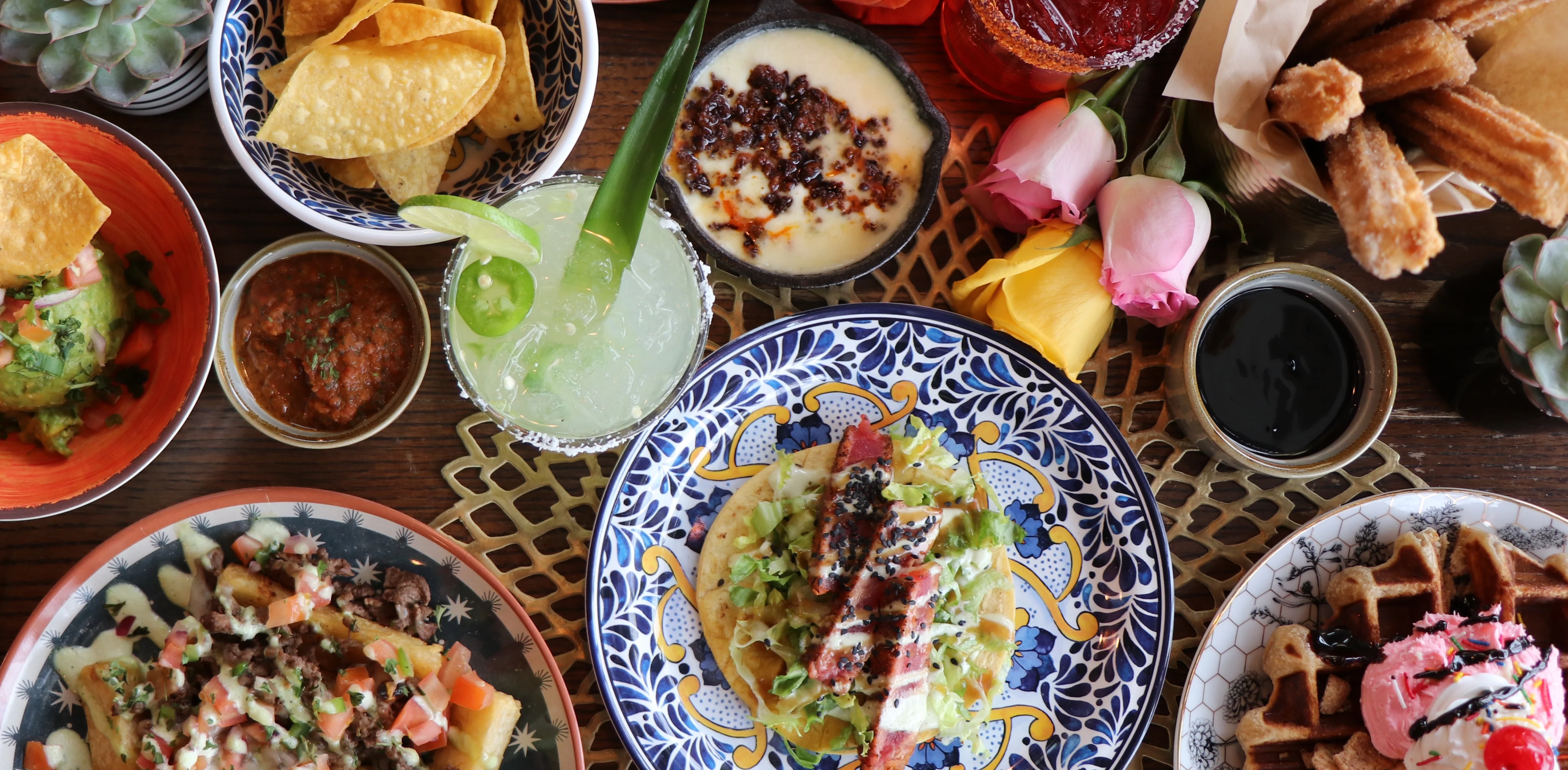 Colorful Mexican feast with tacos, guacamole, and churros