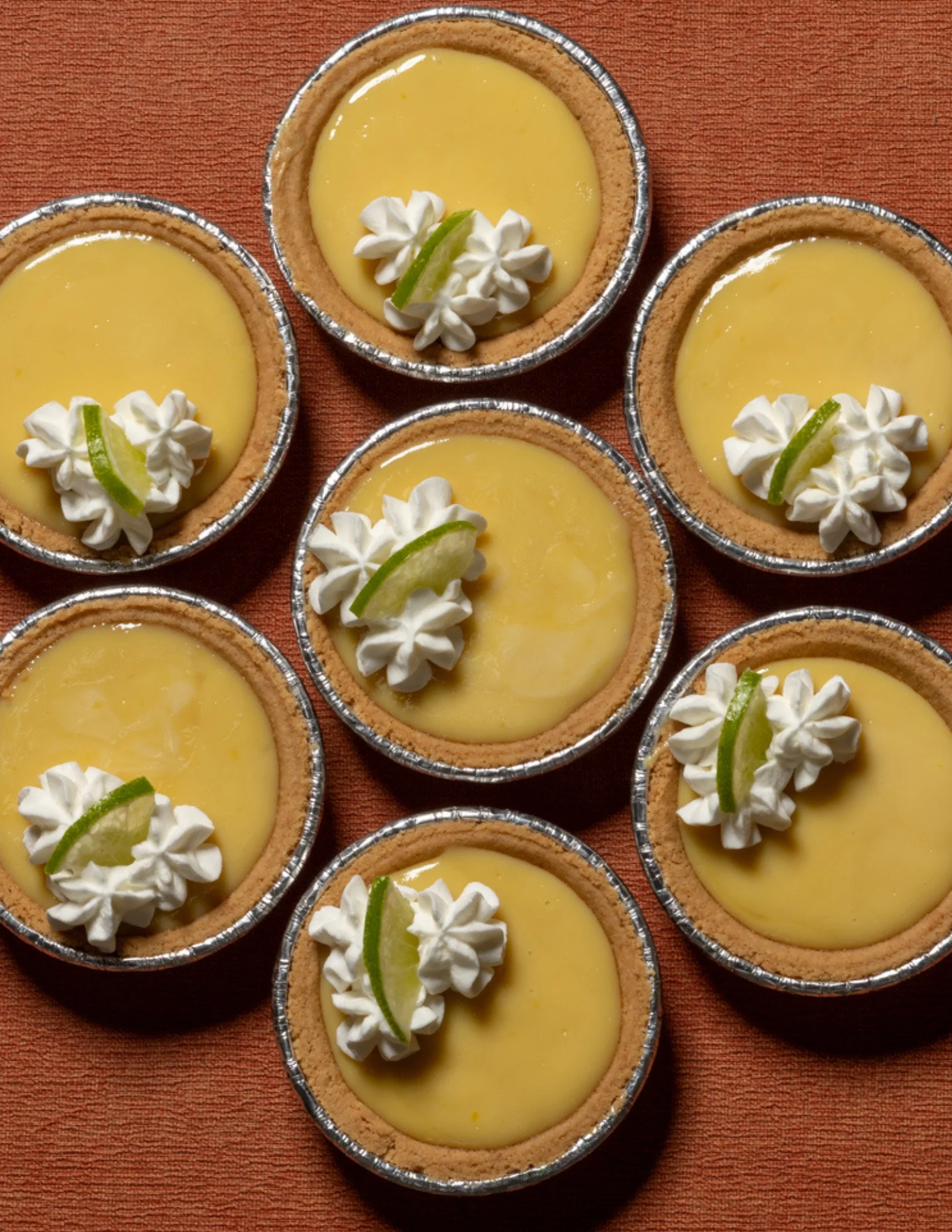 Mini key lime pies with whipped cream and lime garnish