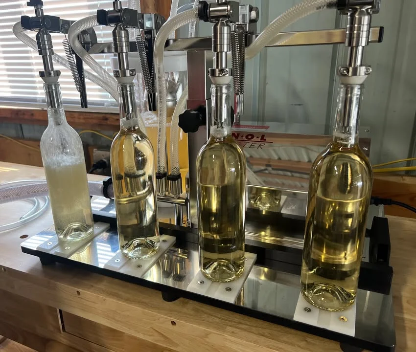 Bottling machine filling wine bottles in a winery