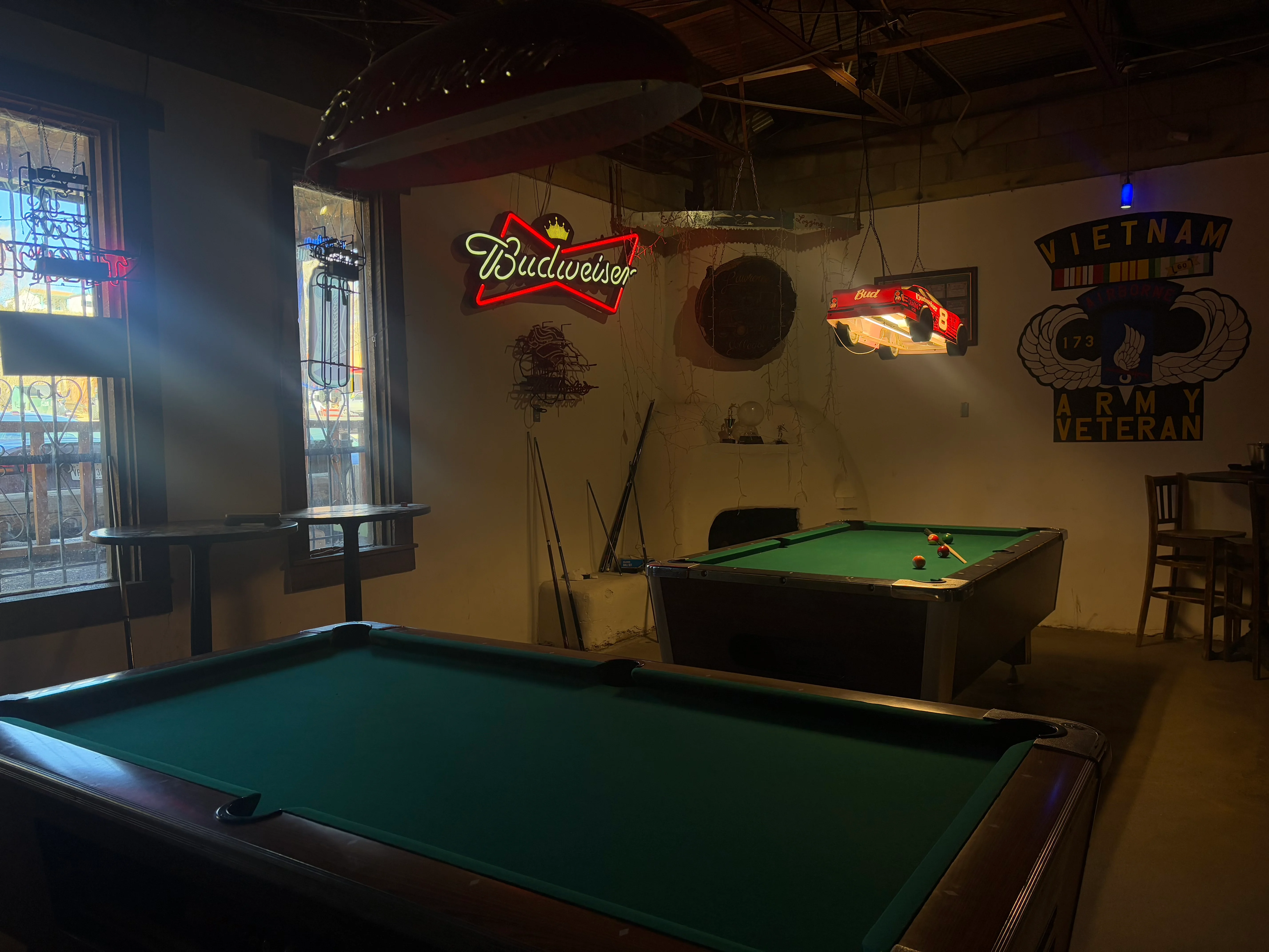 Cozy bar interior with pool tables and neon signs