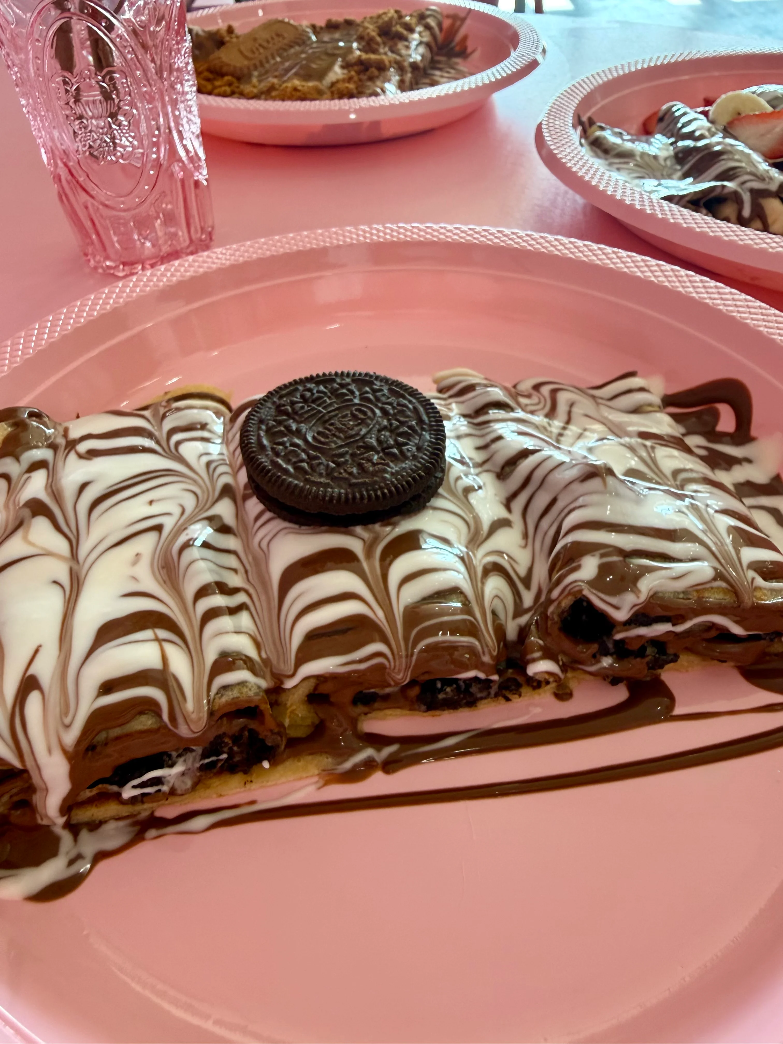 Delicious dessert crepes topped with chocolate, cream, and an Oreo cookie.