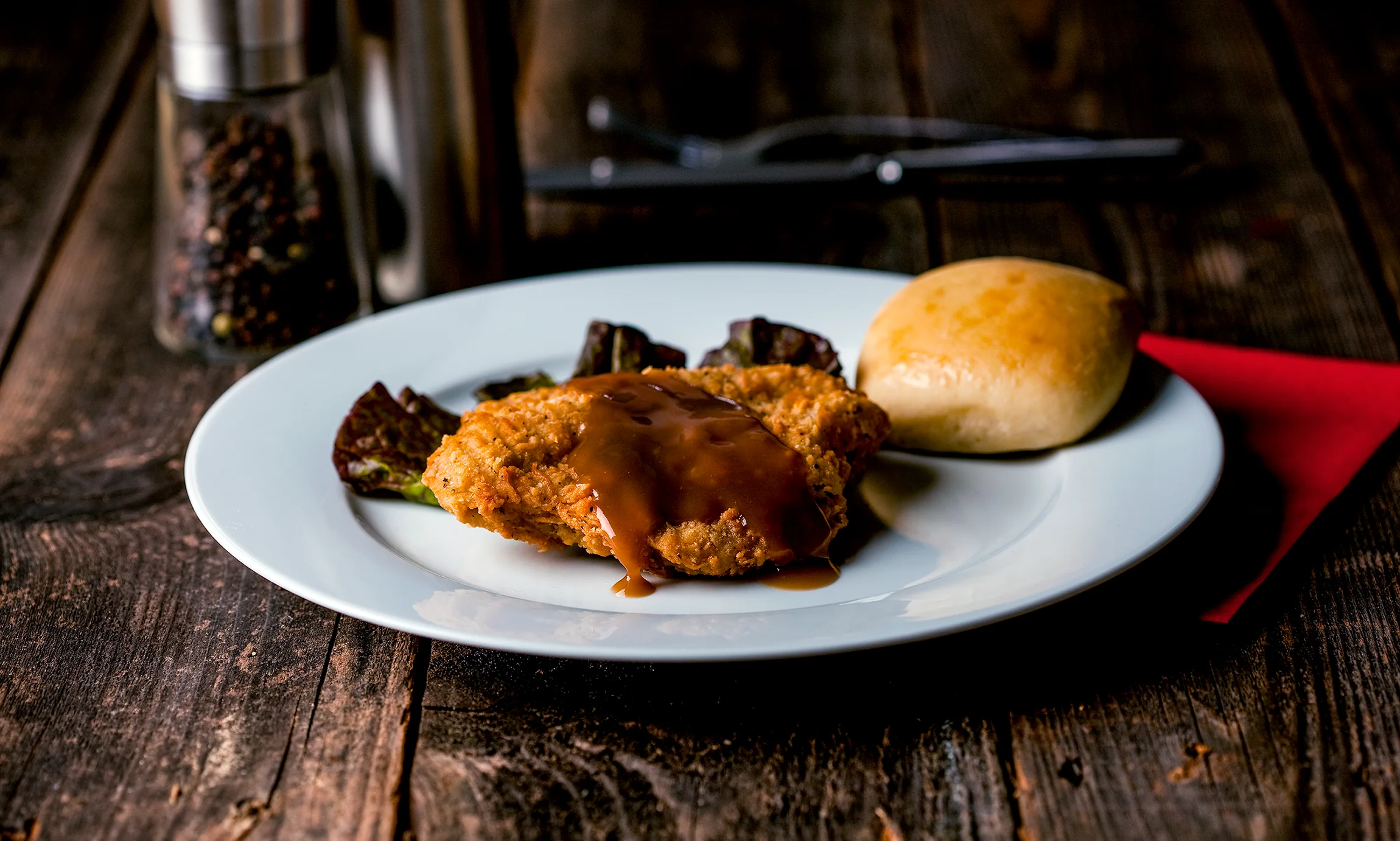 Southern fried chicken with gravy and a roll