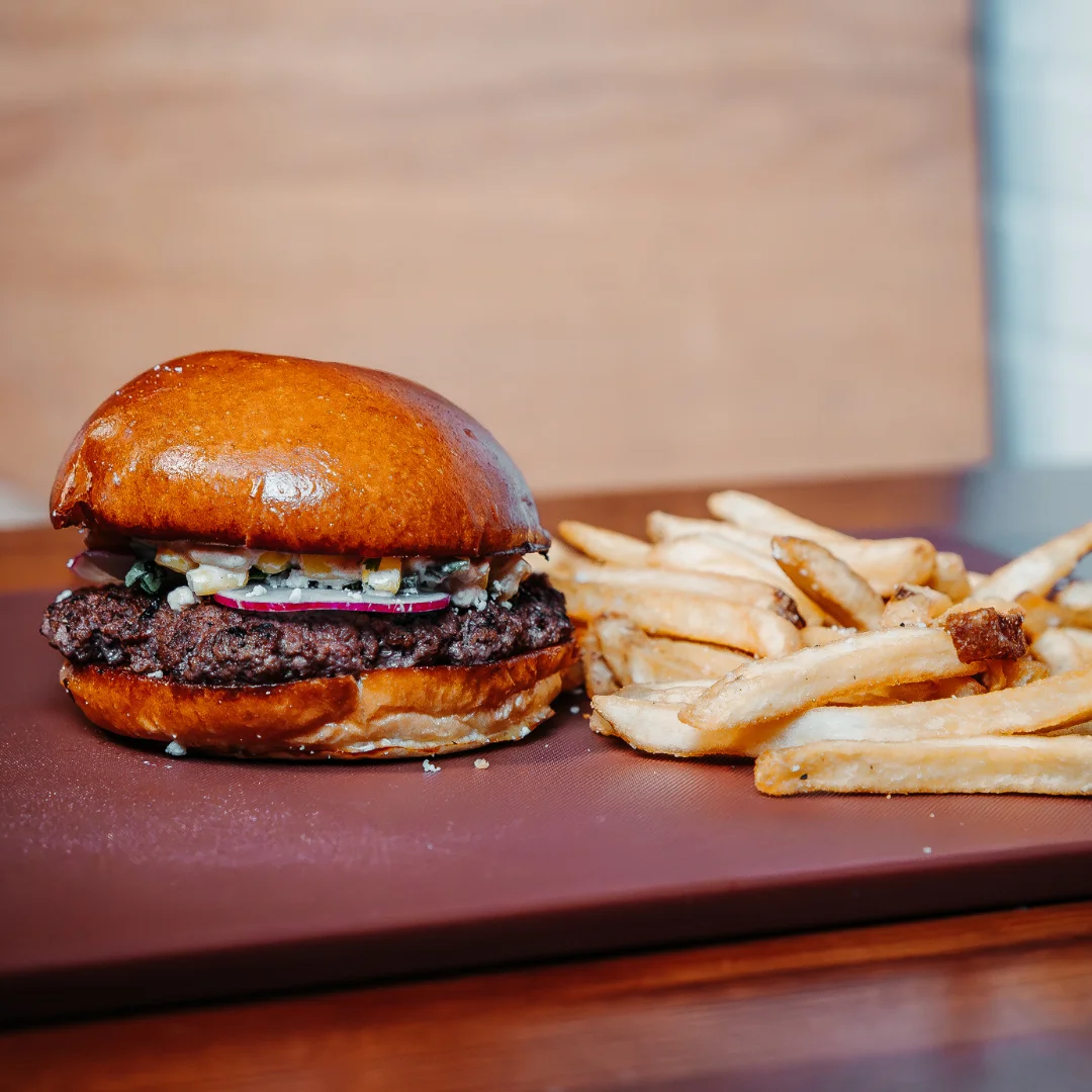 A delicious burger served on a brioche bun accompanied by crispy French fries.
