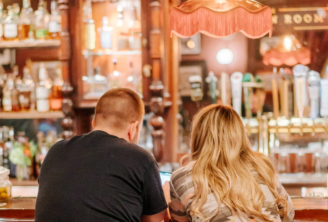 Couple enjoying drinks at a cozy bar counter
