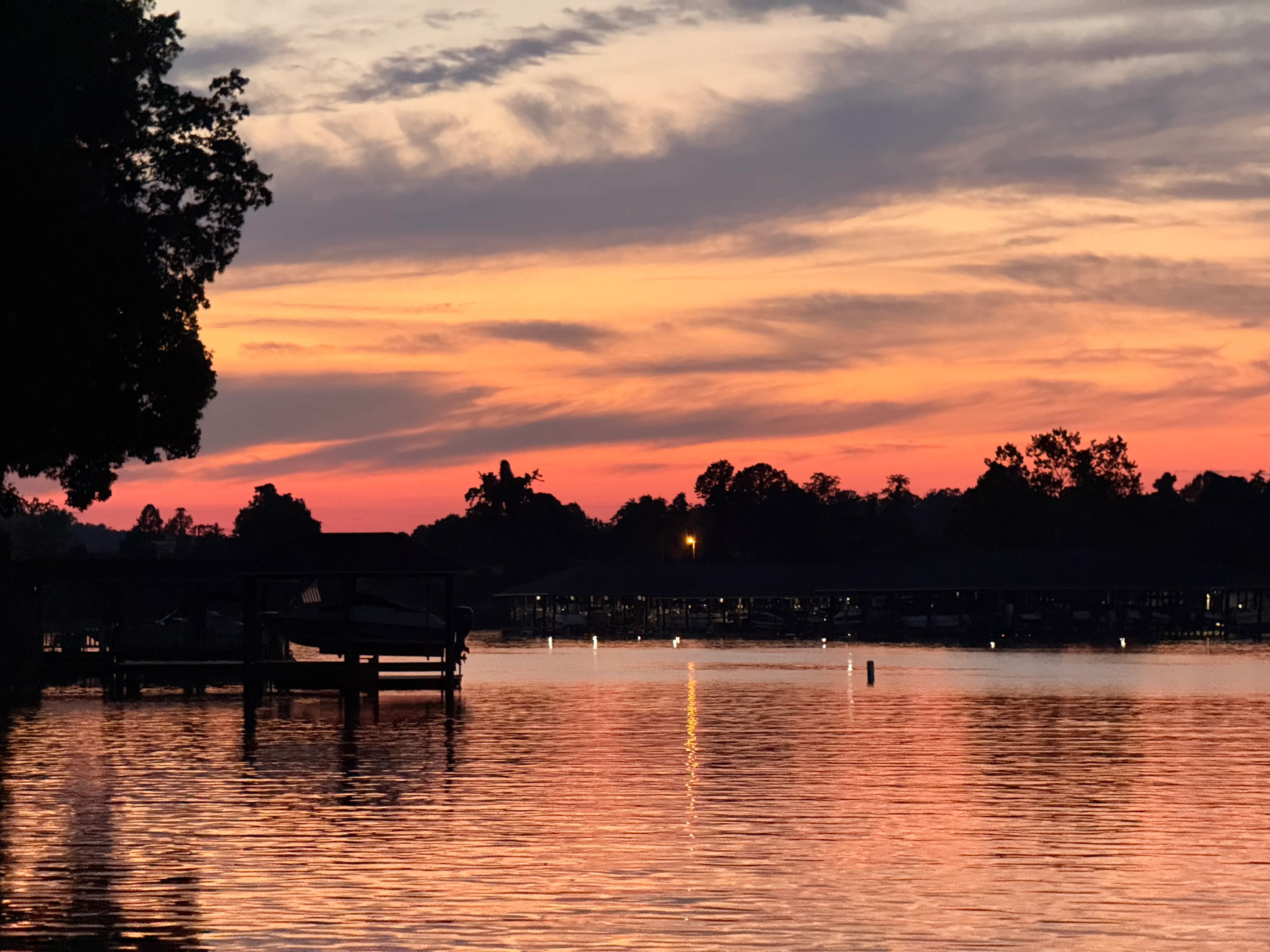 Serene sunset over a lake with vibrant colors and reflections