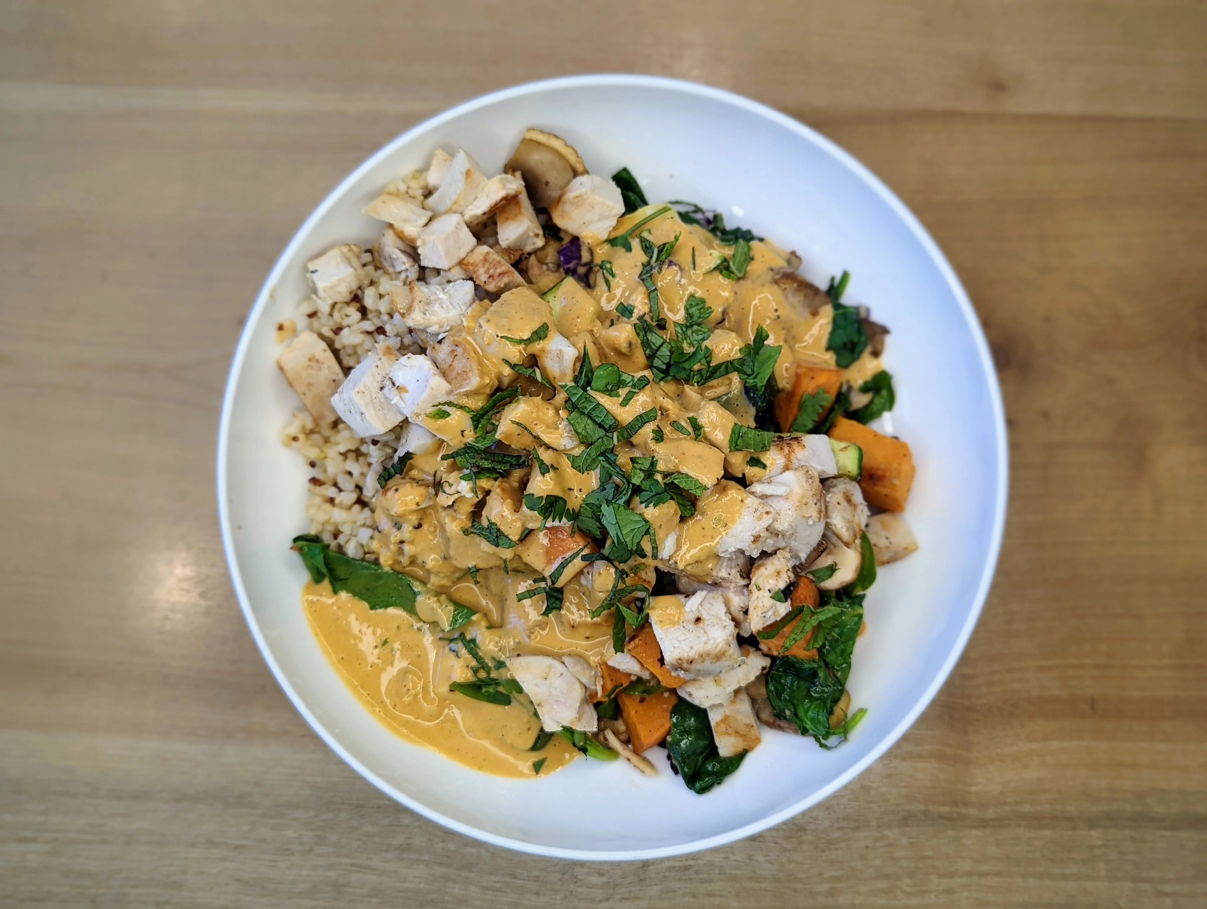 Healthy grain bowl with grilled chicken and creamy sauce