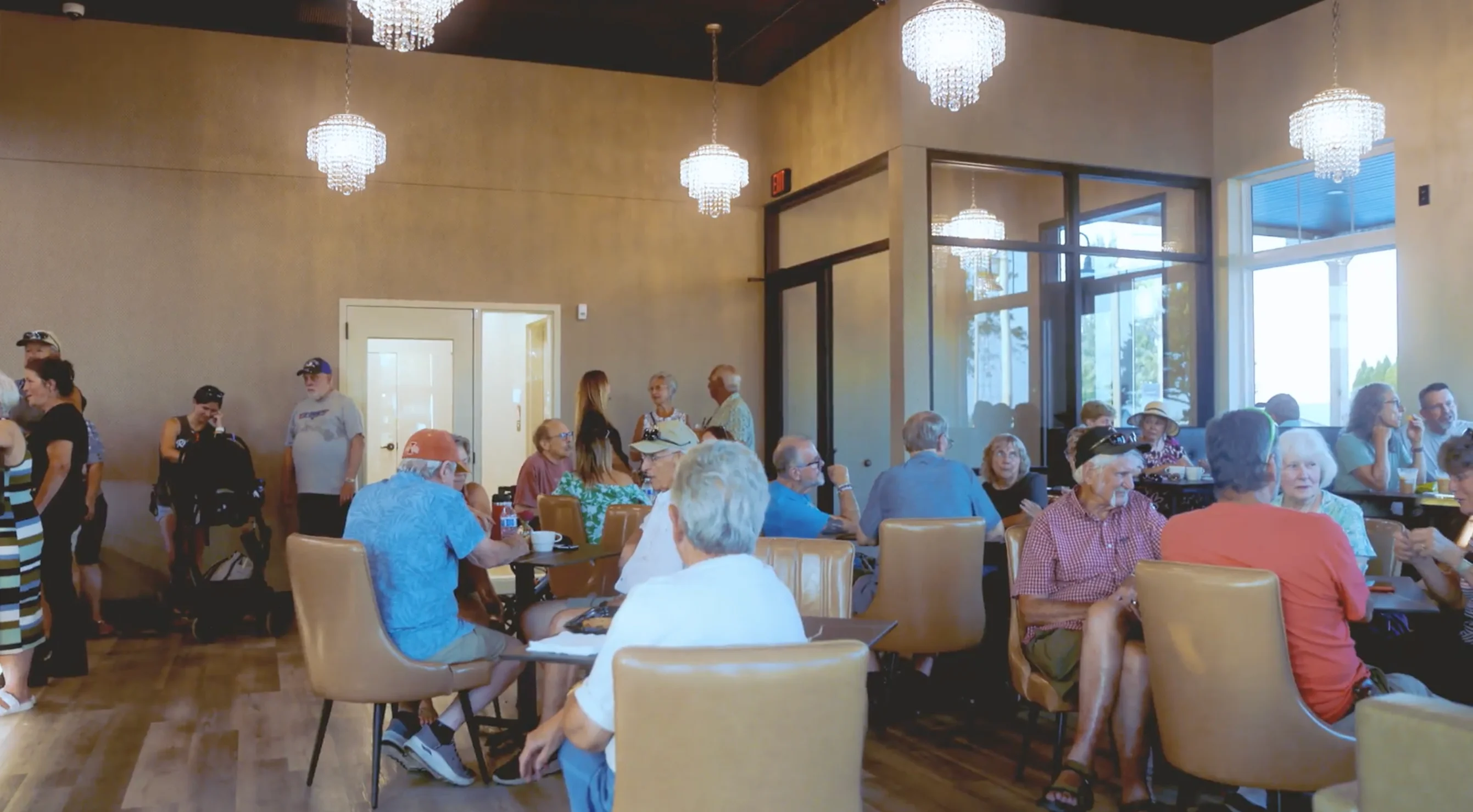 Guests gathering and chatting at tables inside Roosters Coffee