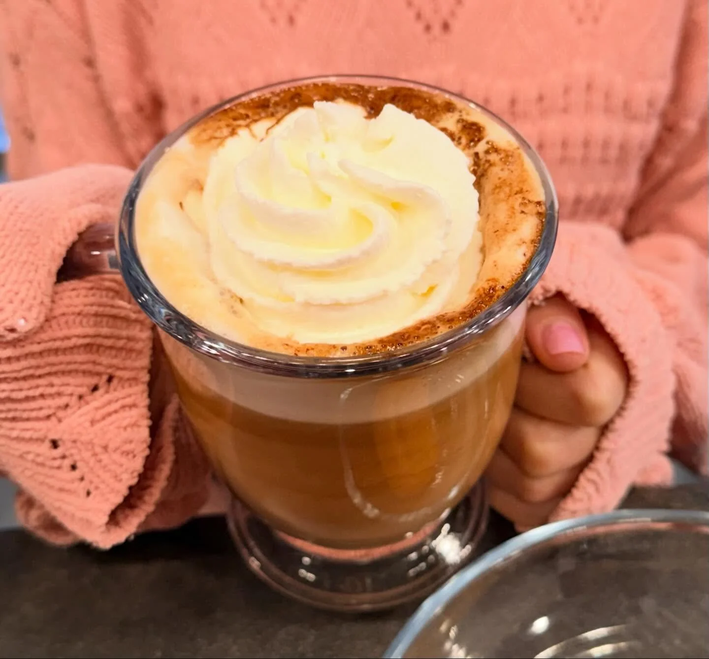 Creamy latte topped with whipped cream and cocoa powder