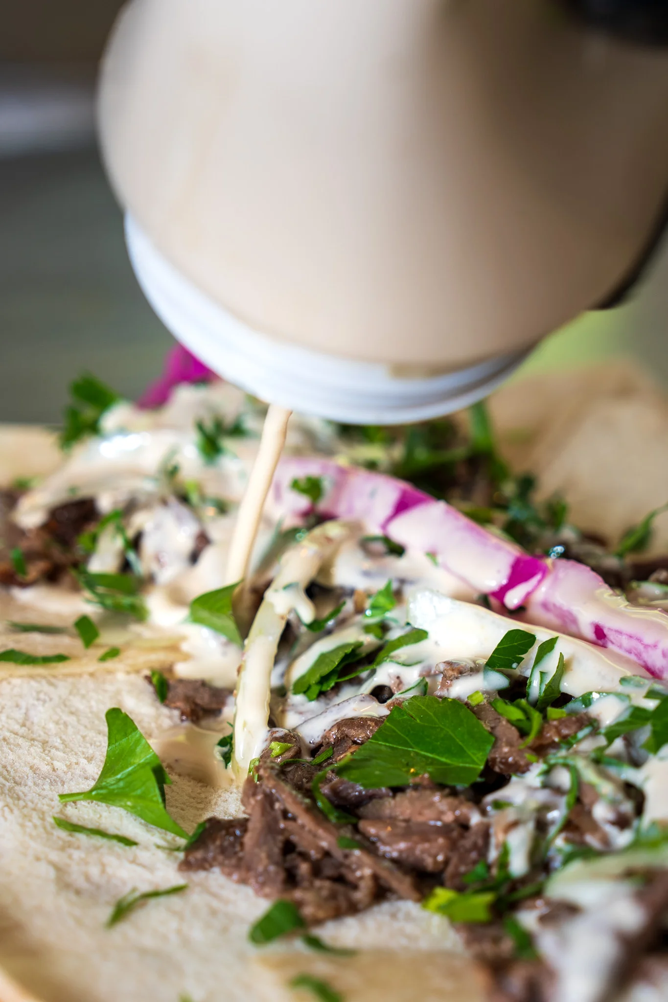 Delicious shawarma wrap drizzled with sauce and fresh herbs