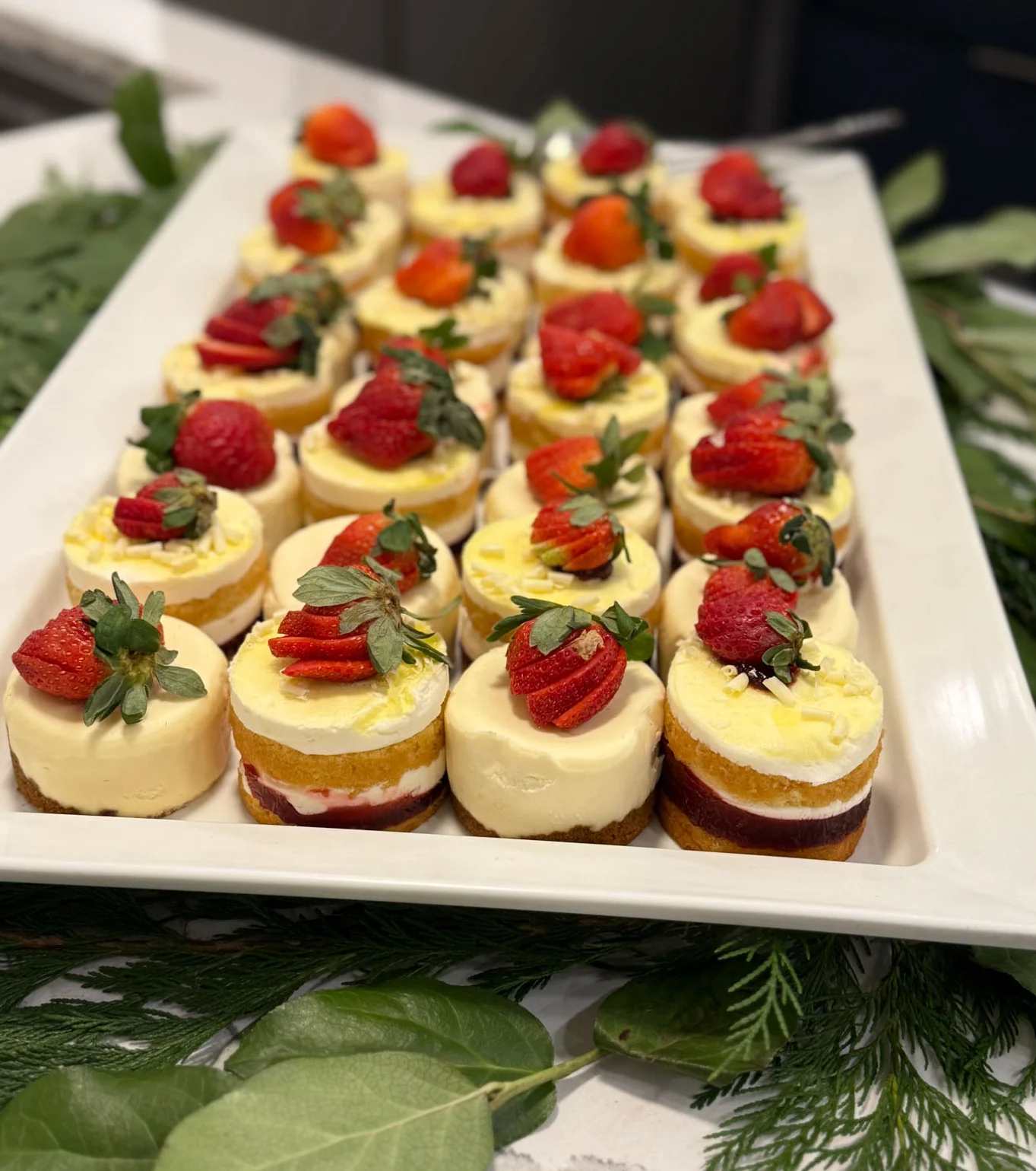 A tray of custard-like desserts topped with strawberries.