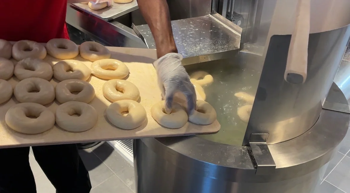 Freshly boiled bagels ready for baking