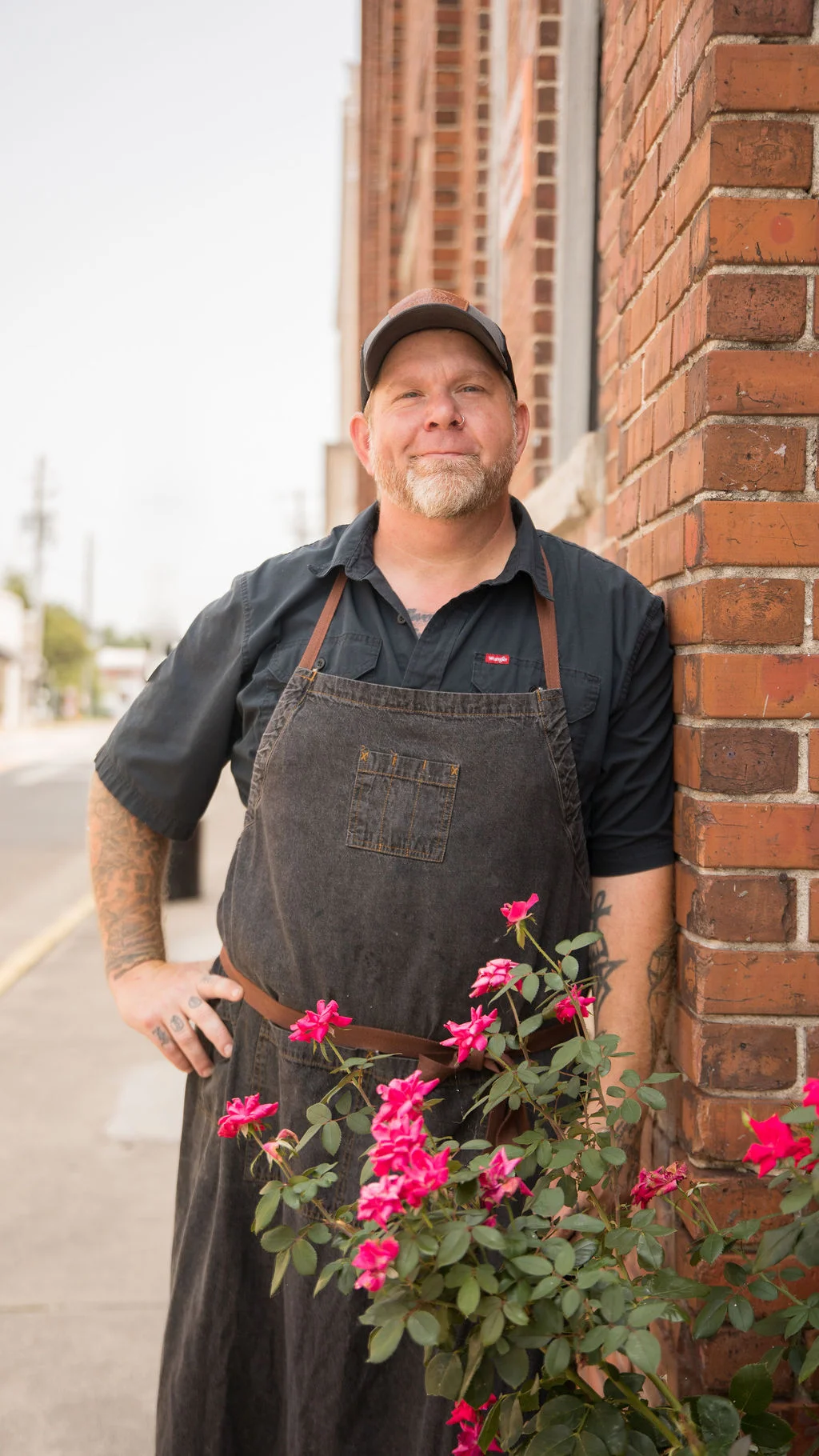 Chef posing outside a restaurant with flowers